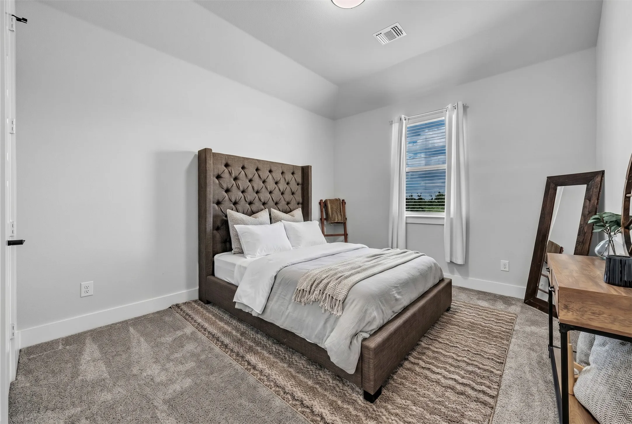 Spacious room featuring vaulted ceilings, a single window with blinds, and light-colored wall paint