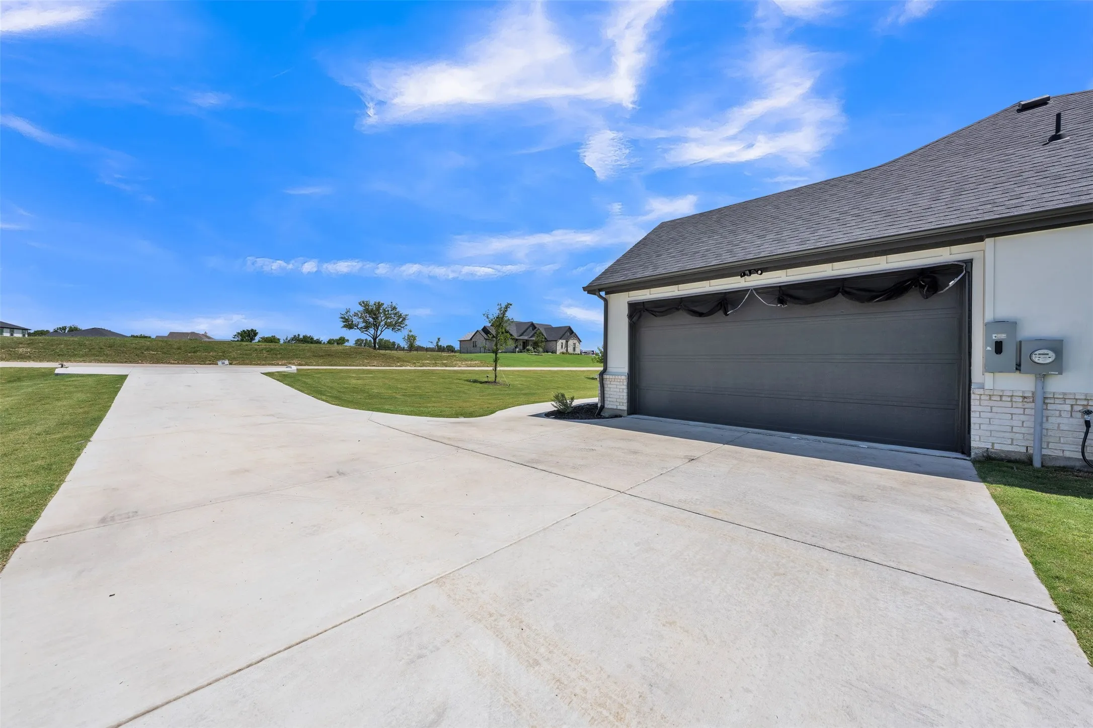 Expansive concrete driveway with a two-car garage