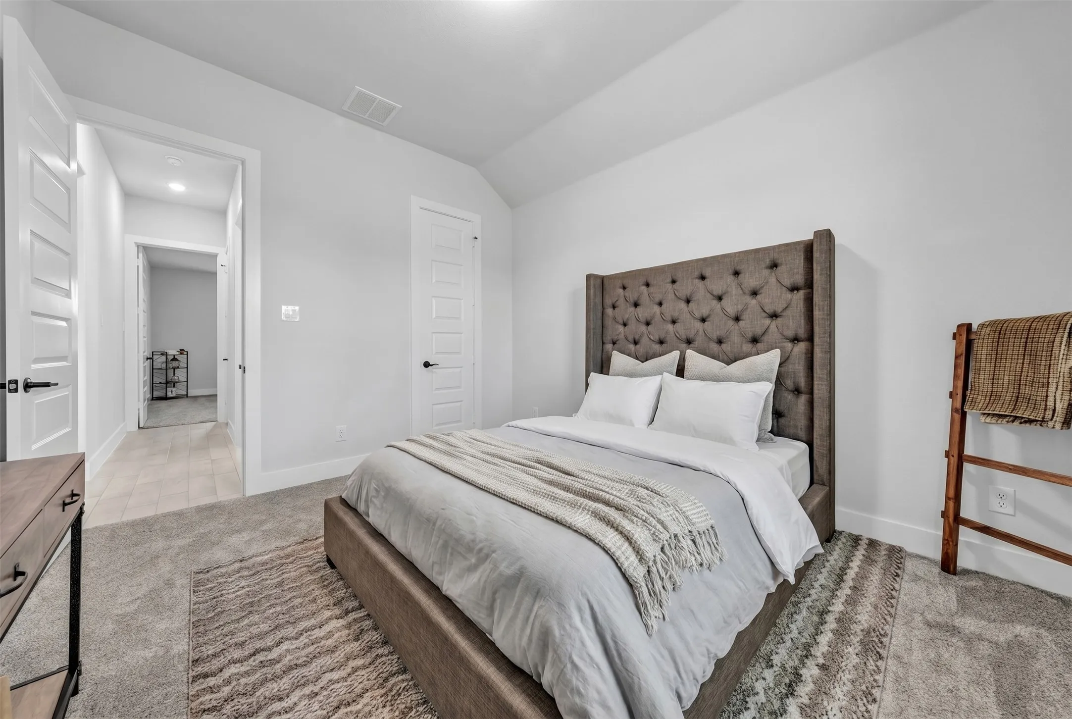Carpeted flooring, white walls, white doors with dark hardware, recessed lighting