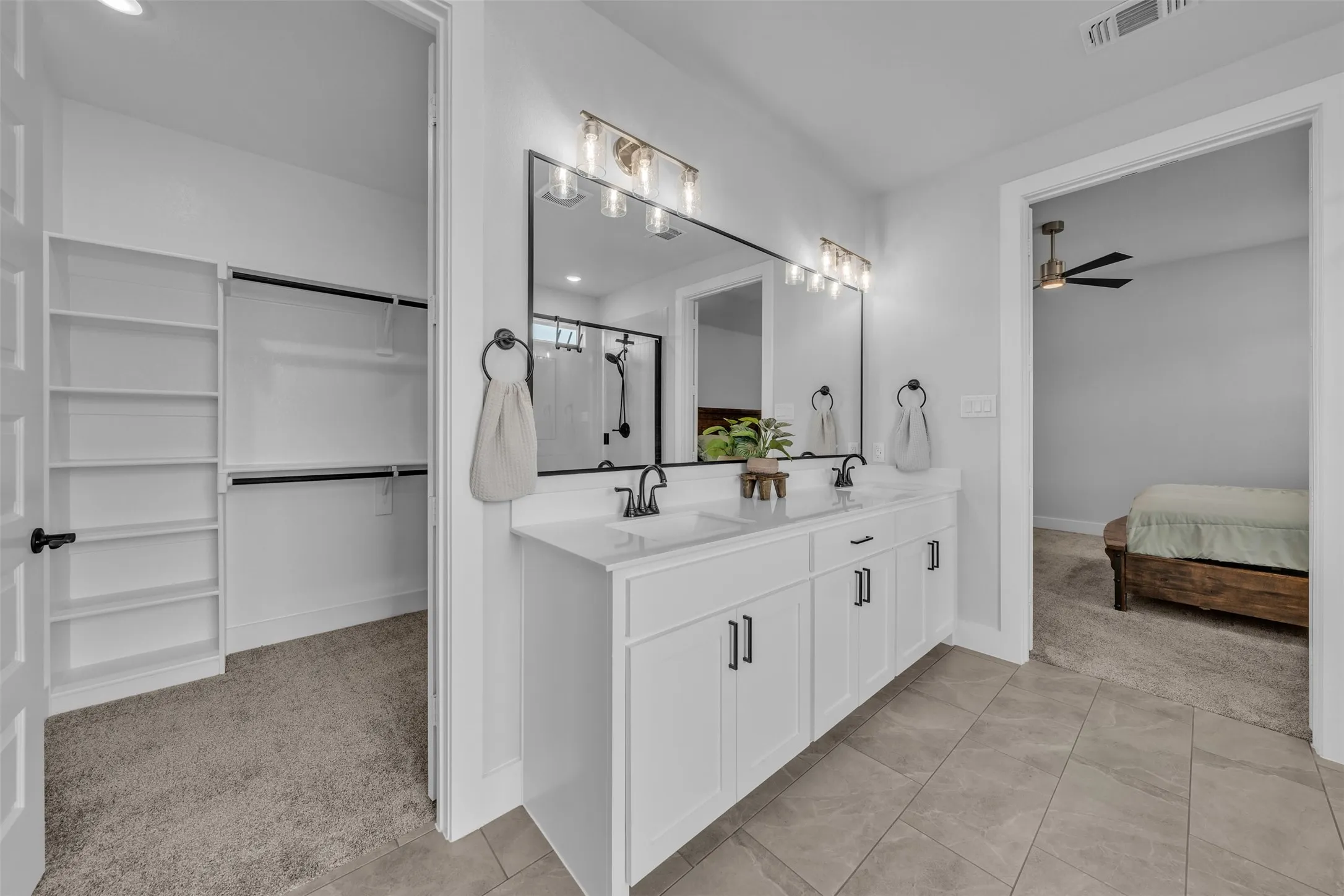 Double vanity with dual sinks, white cabinetry, and matte black fixtures