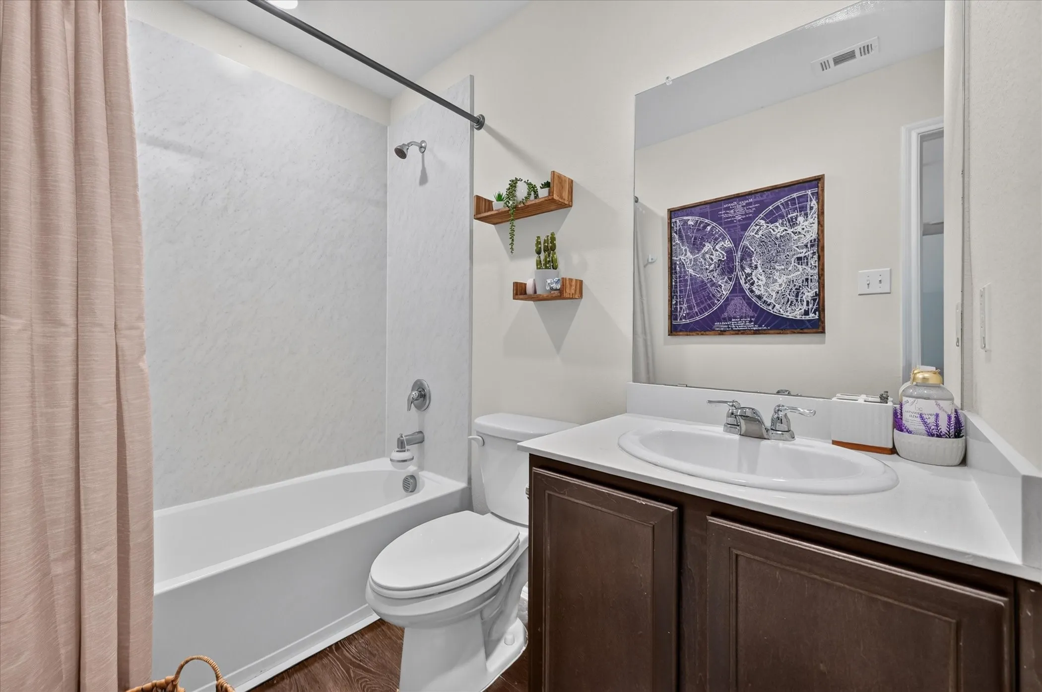 White bathtub with an integrated shower, chrome fixtures, and a textured surround