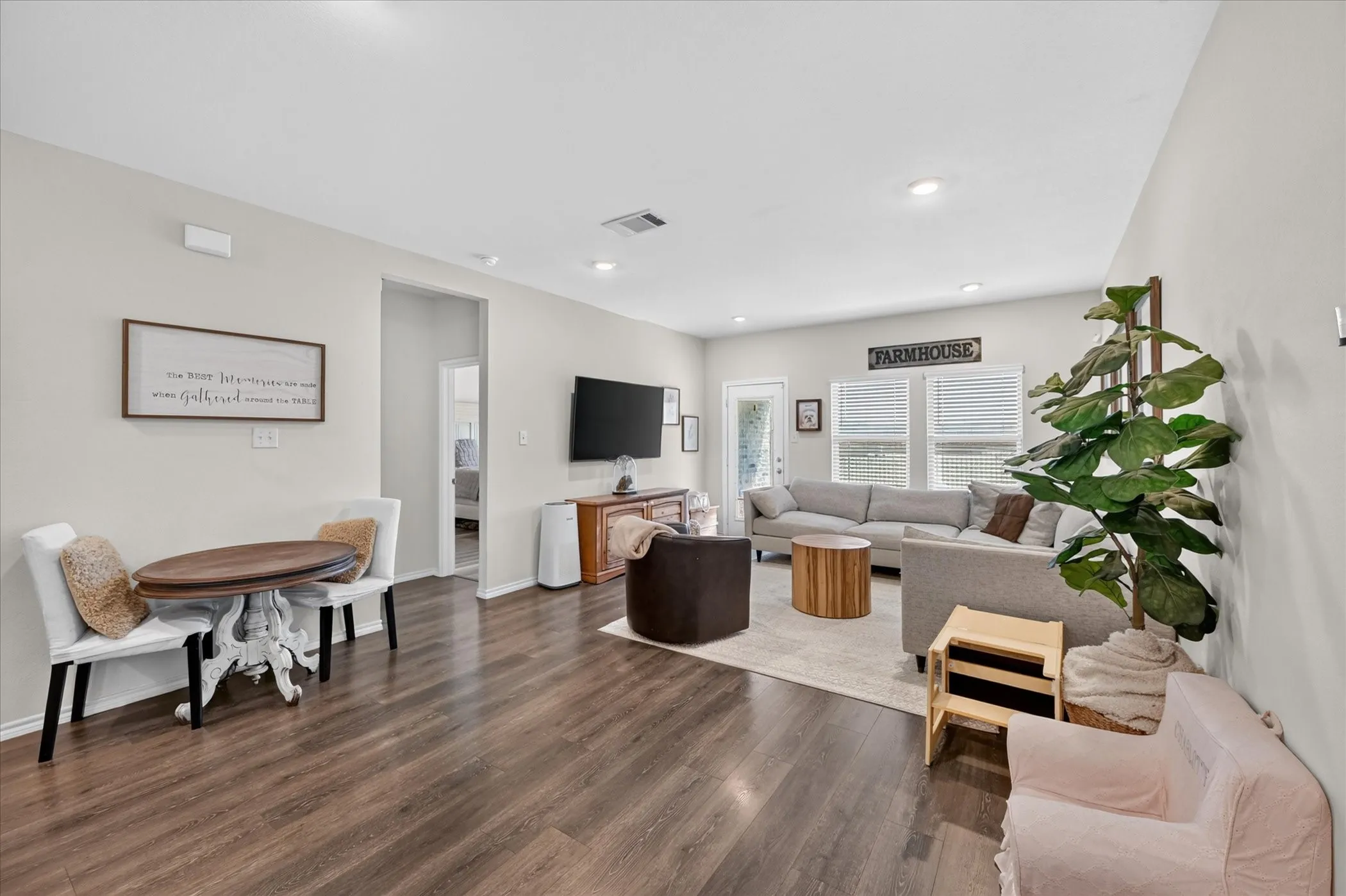 Spacious open-concept living area featuring wood-finish flooring, recessed lighting, and ample natural light from multiple windows