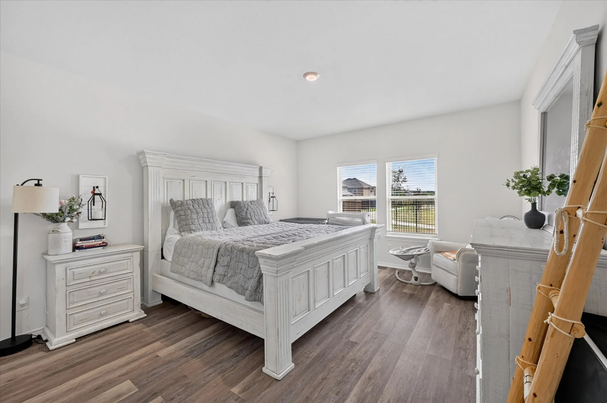Wood-finish flooring, white walls, recessed lighting, and dual windows