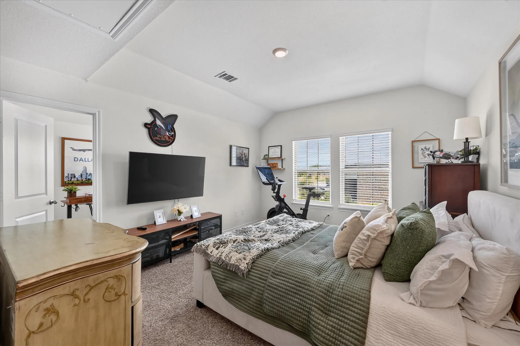 Vaulted ceiling, recessed lighting, double windows with blinds, carpeted flooring, and a white interior door