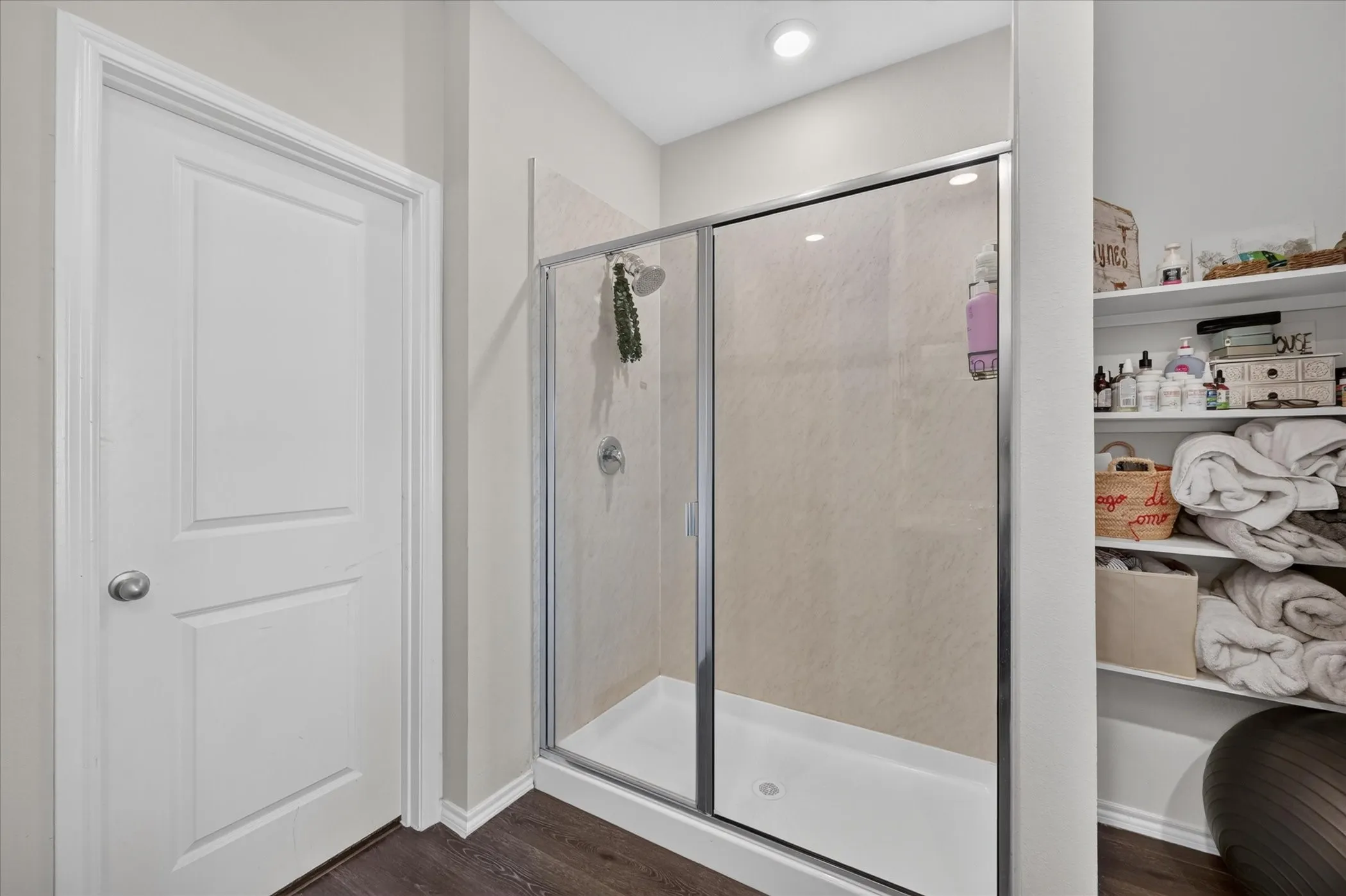 Shower with sliding glass enclosure, white shower pan, and tiled walls