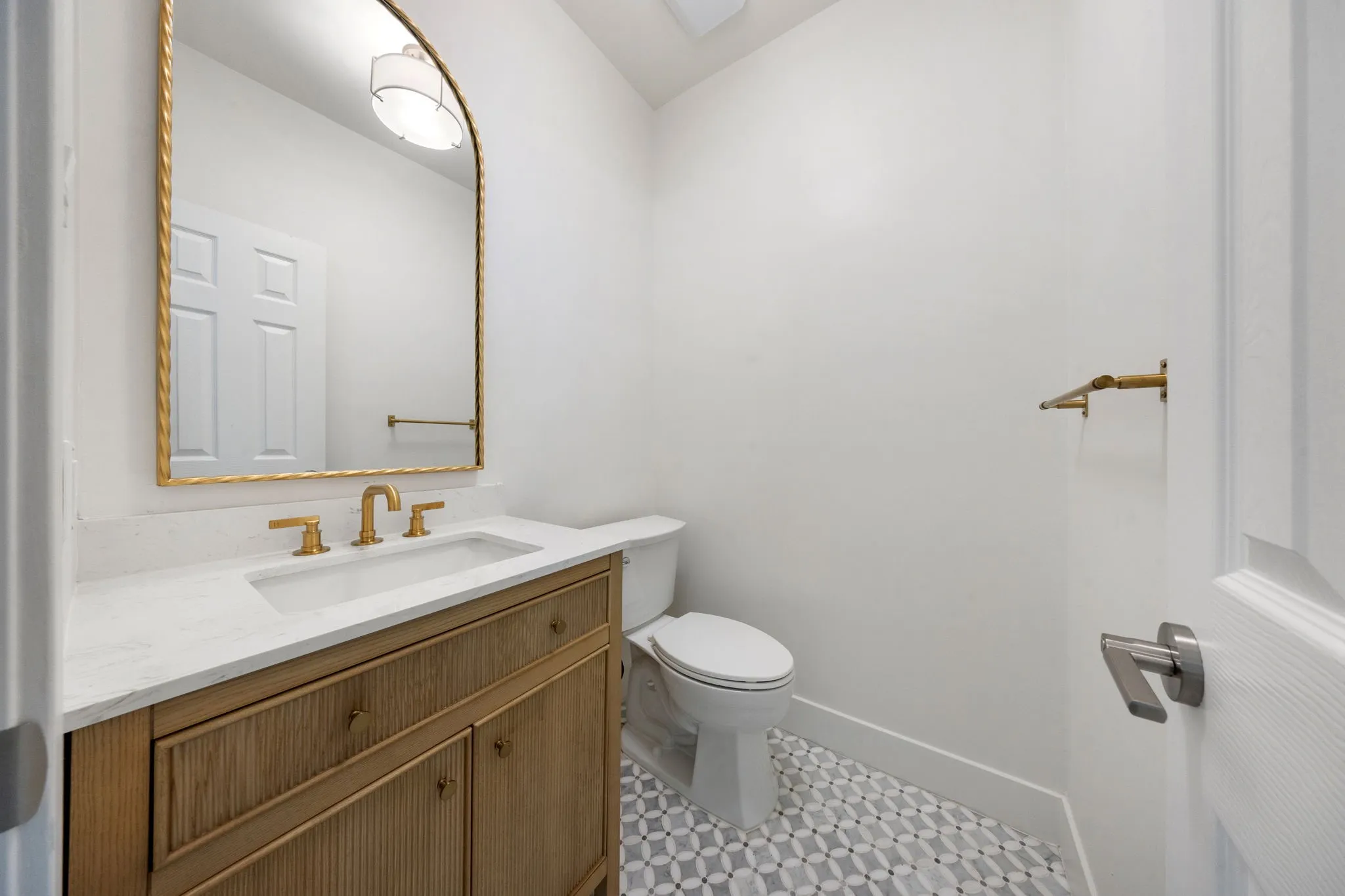 Powder room featuring a wood-finish vanity with a white countertop and integrated rectangular sink