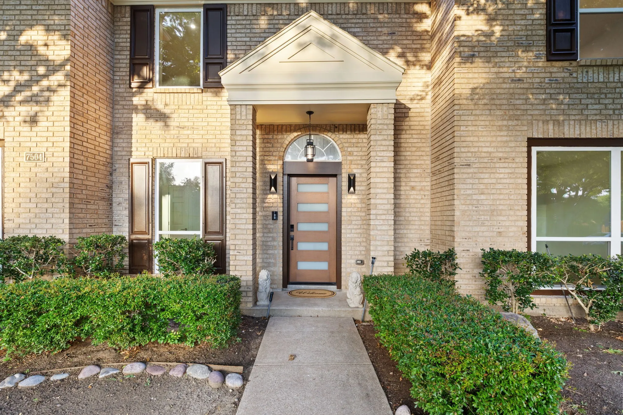 Brick exterior with a covered entry featuring a transom window above the front door