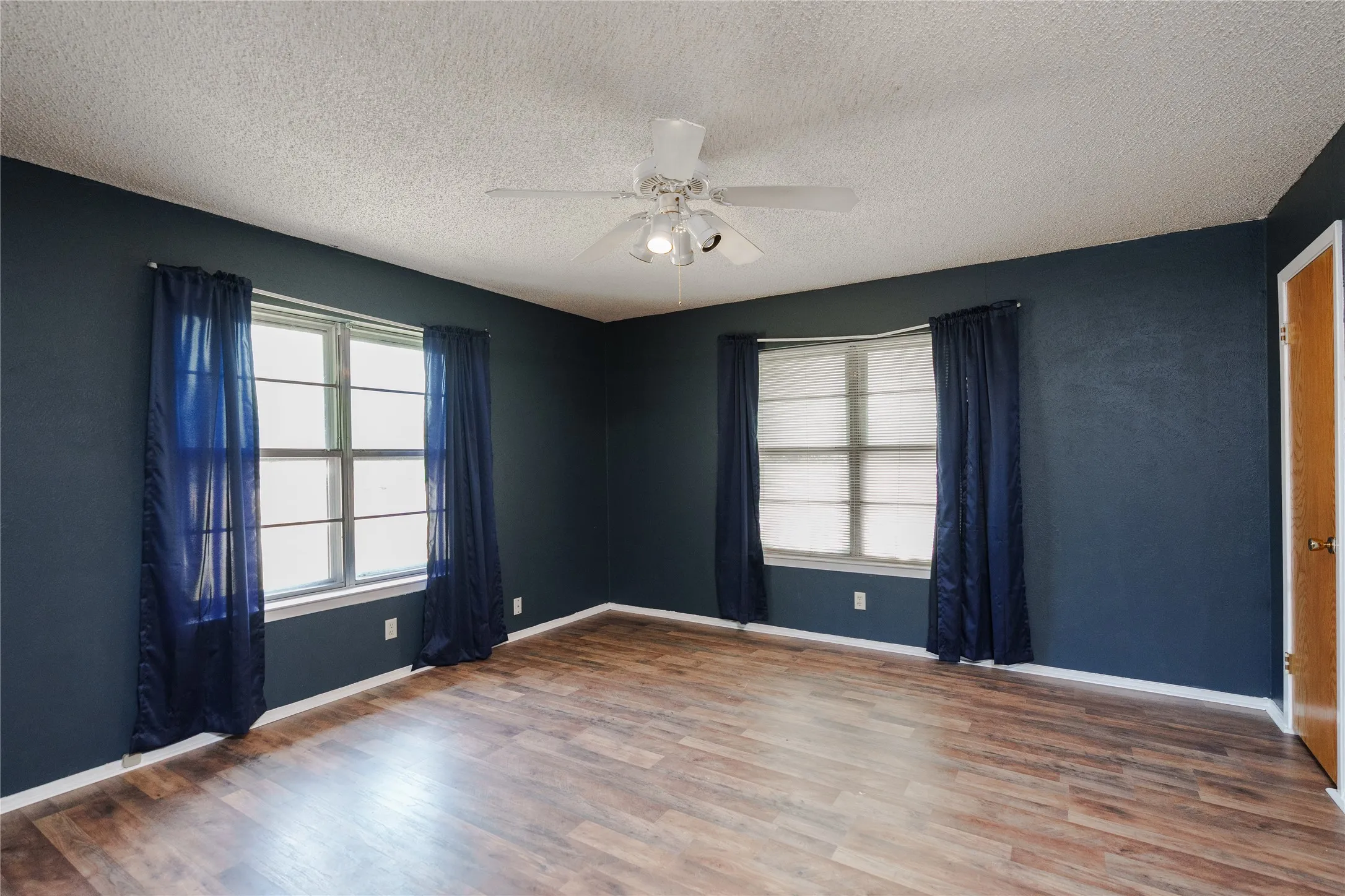 Wood-finish flooring, recessed window, and ceiling fan with integrated lighting