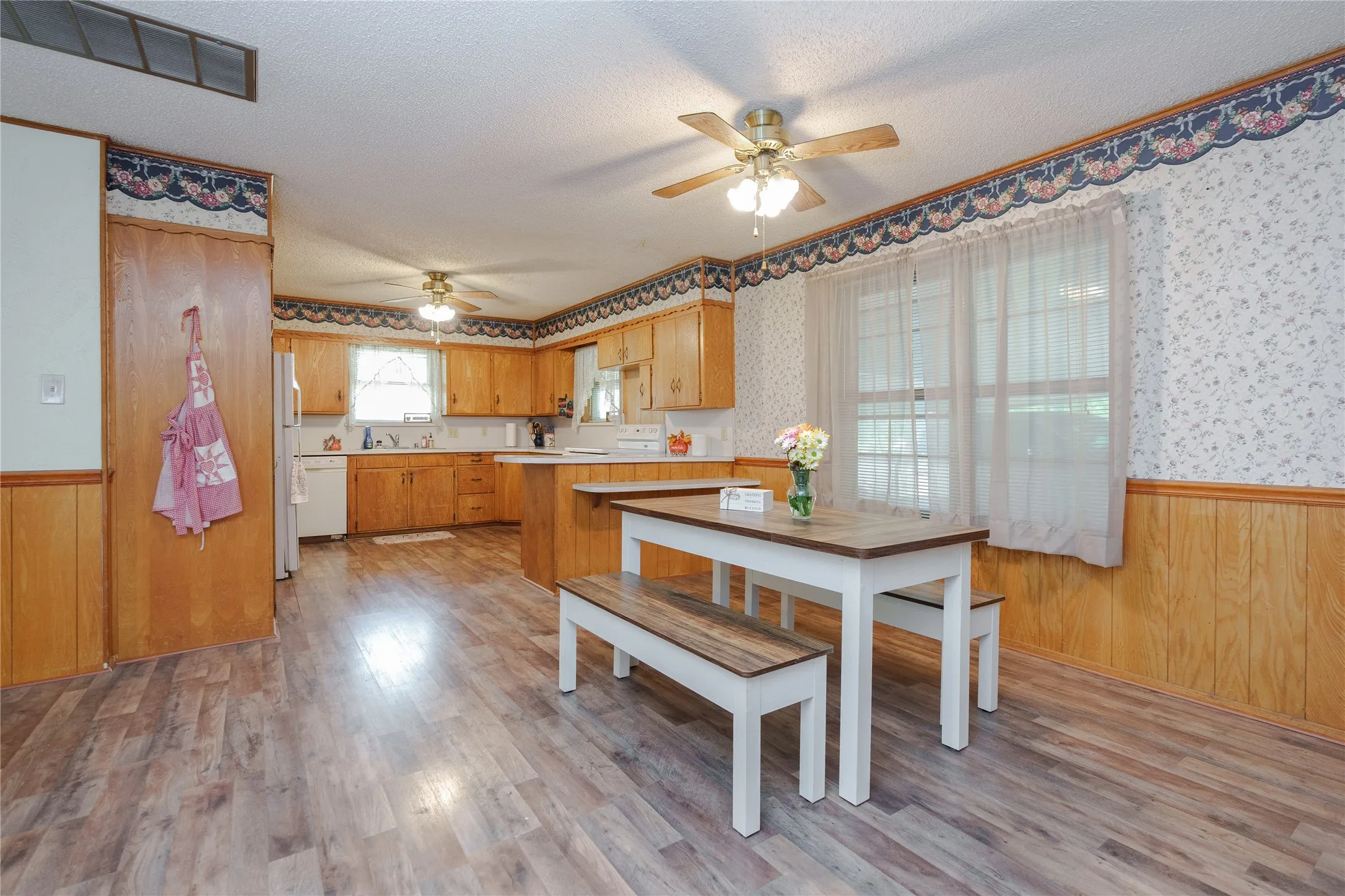 Wood-finish flooring throughout, with a ceiling fan and a built-in kitchen island