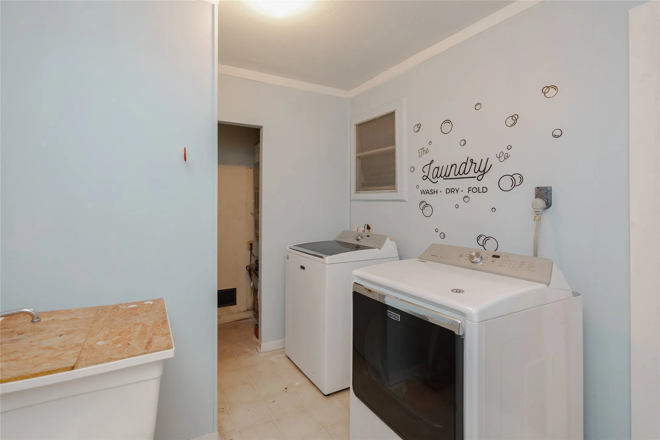 Utility room with light-toned walls and crown molding