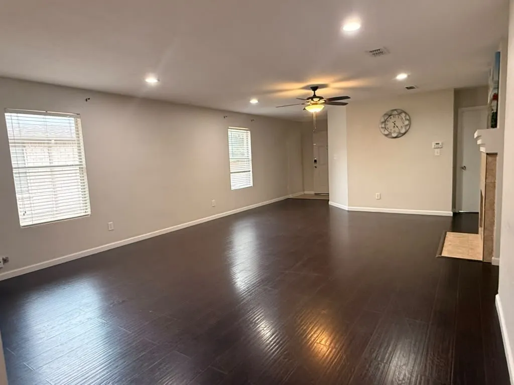 Spacious interior featuring dark wood-finish flooring, recessed lighting, and a ceiling fan