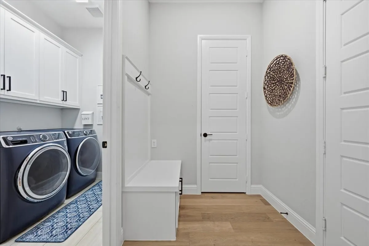 Laundry Rm with cabinets and sink to left, MudRoom Hall, garage to right