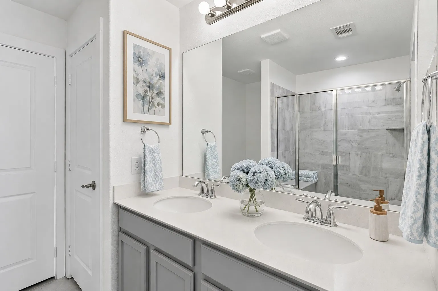 A thoughtfully designed primary suite retreat with dual quartz vanities, an expansive walk-in shower, and a spacious walk-in closet. Virtually staged to show potential design options.