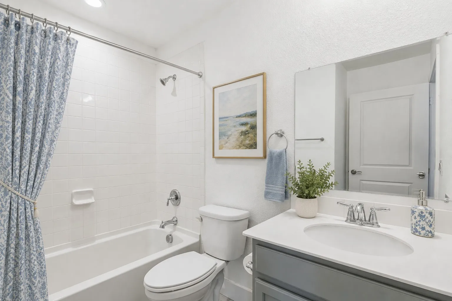 The primary bath showcases quartz countertops and an oversized walk-in shower with built-in seating. Virtually staged to show possible design options. Virtually staged to show potential furniture placement.
