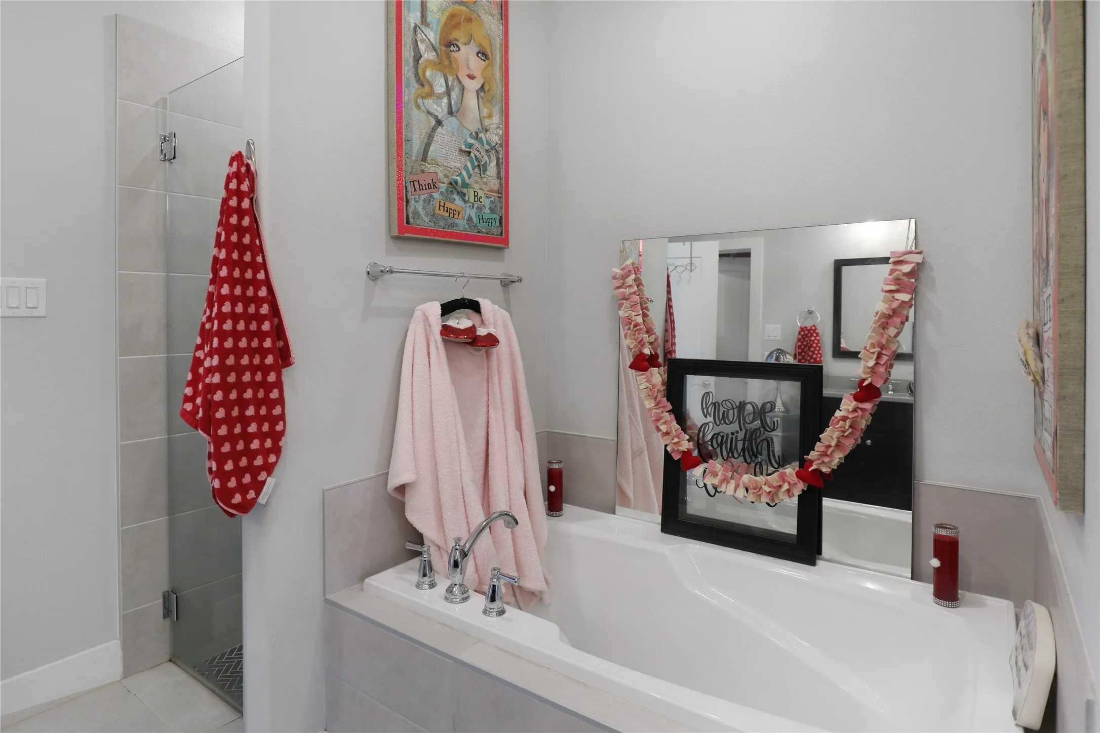 Built-in soaking tub with chrome fixtures, glass-enclosed shower, and light gray wall tiling