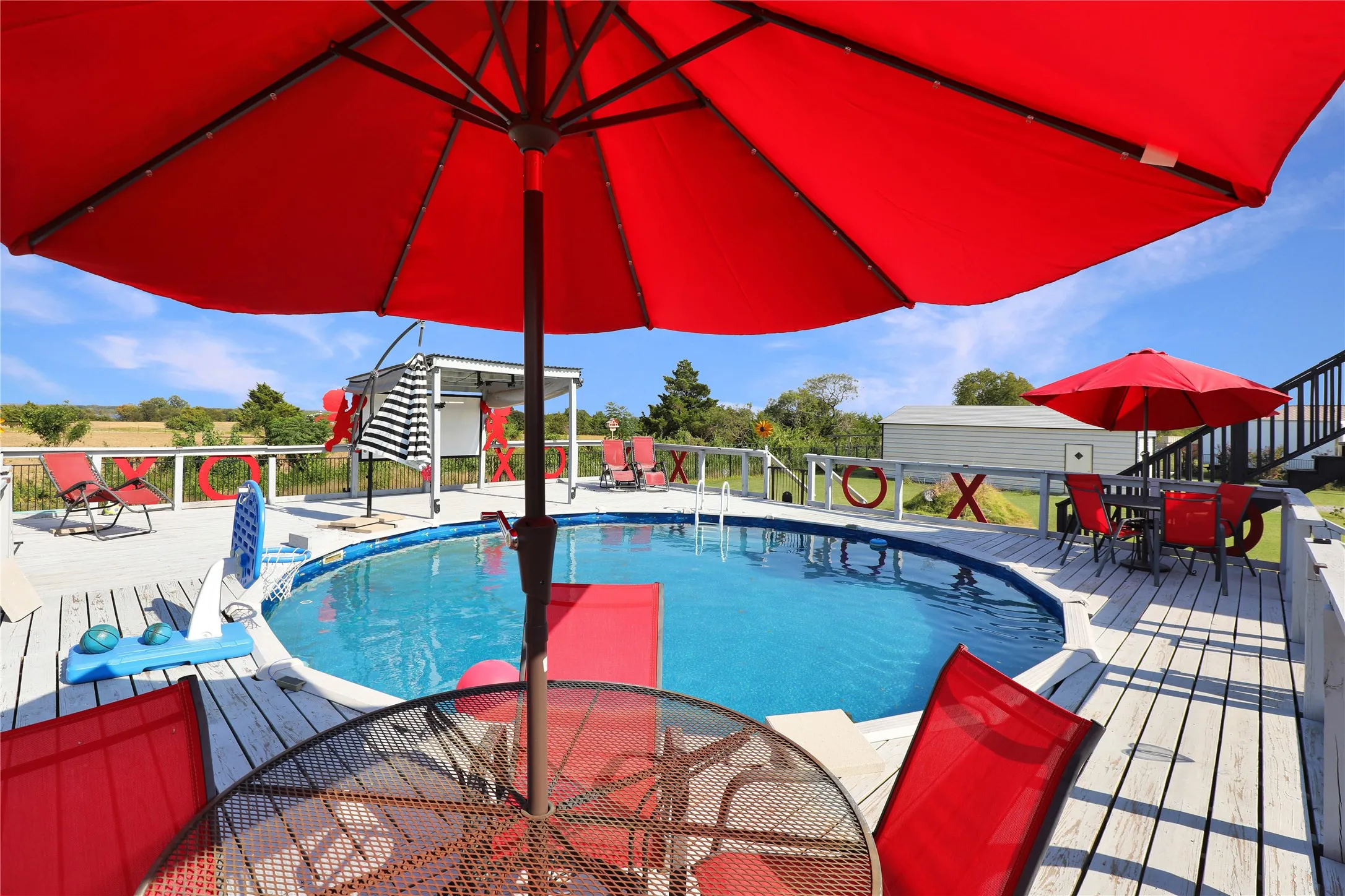 Above-ground swimming pool with surrounding wood-finish deck
