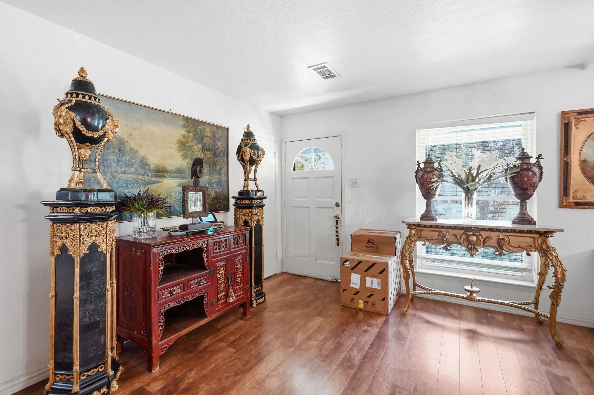 Wood-finish flooring with white walls and a white paneled door