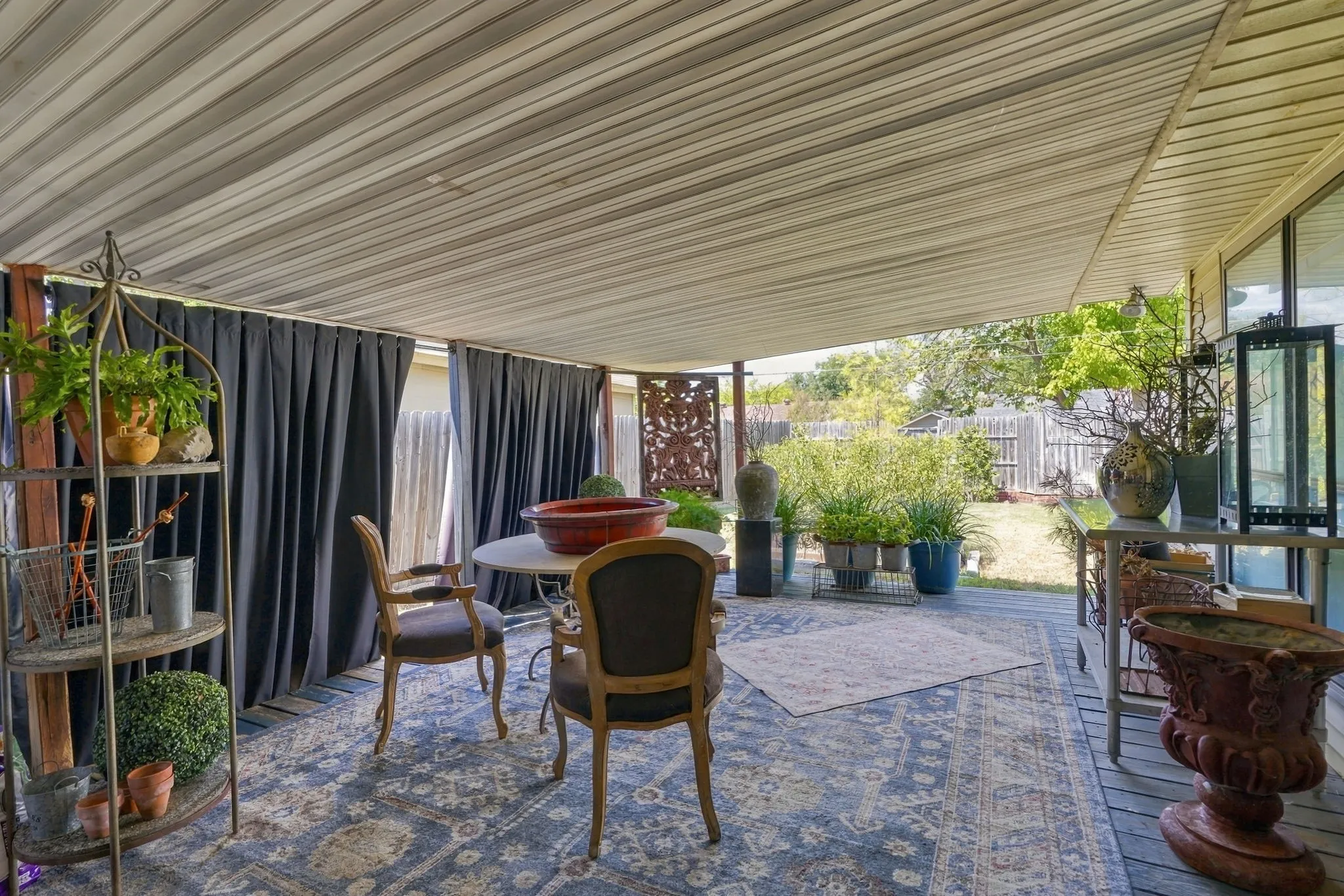 Covered patio featuring a slatted ceiling and wood-finish decking