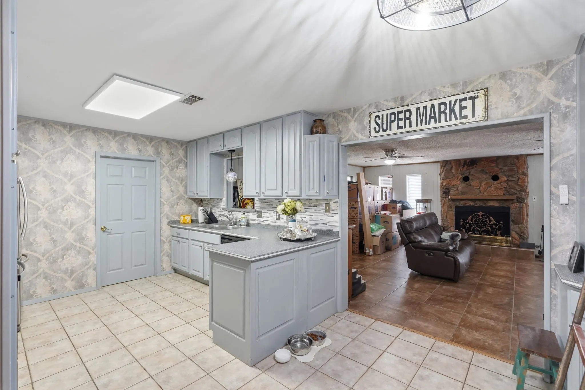 Kitchen featuring light blue cabinetry, tiled flooring, tiled backsplash, and recessed ceiling lighting
