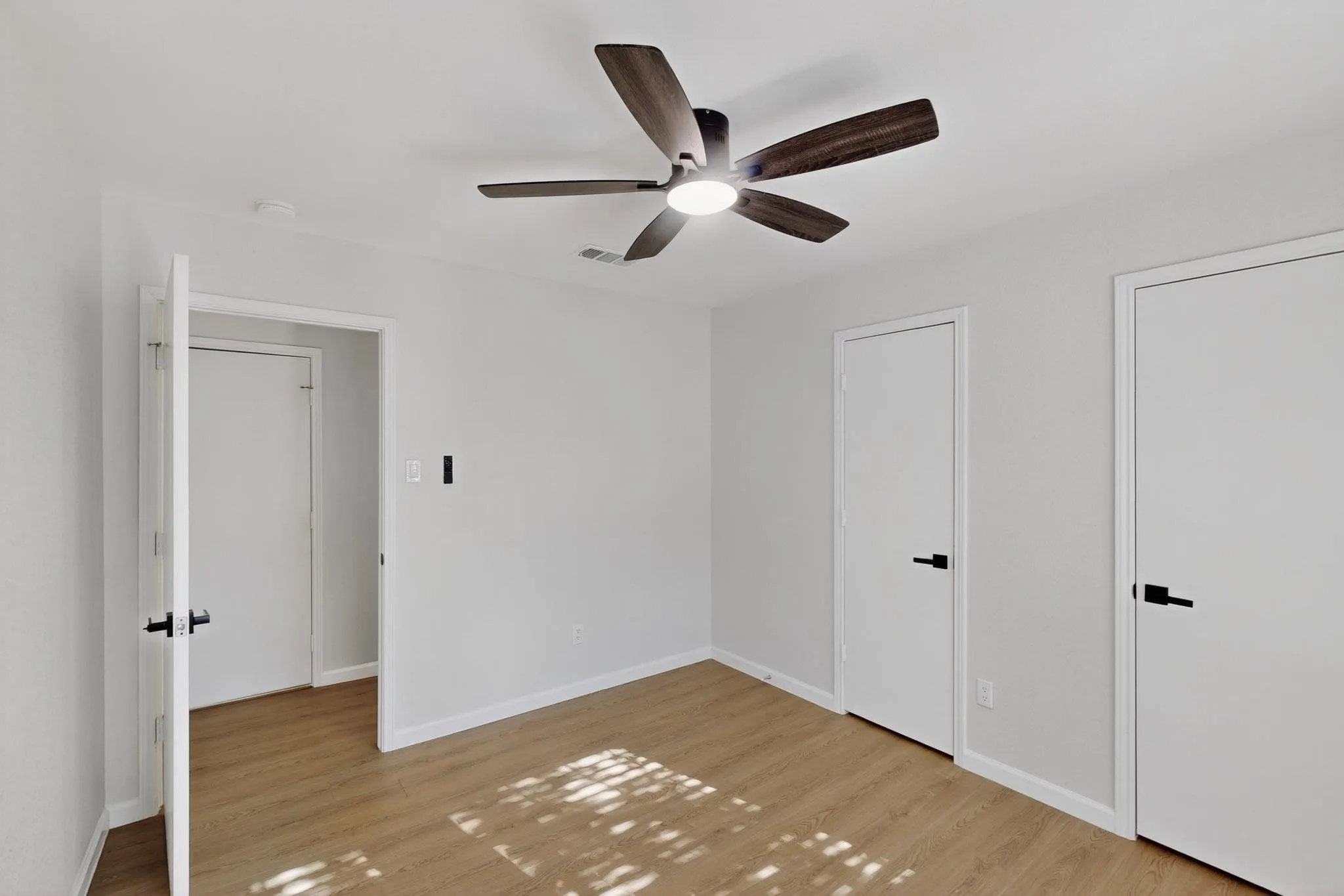 Hardwood-finish flooring, recessed lighting, and a ceiling fan with integrated illumination