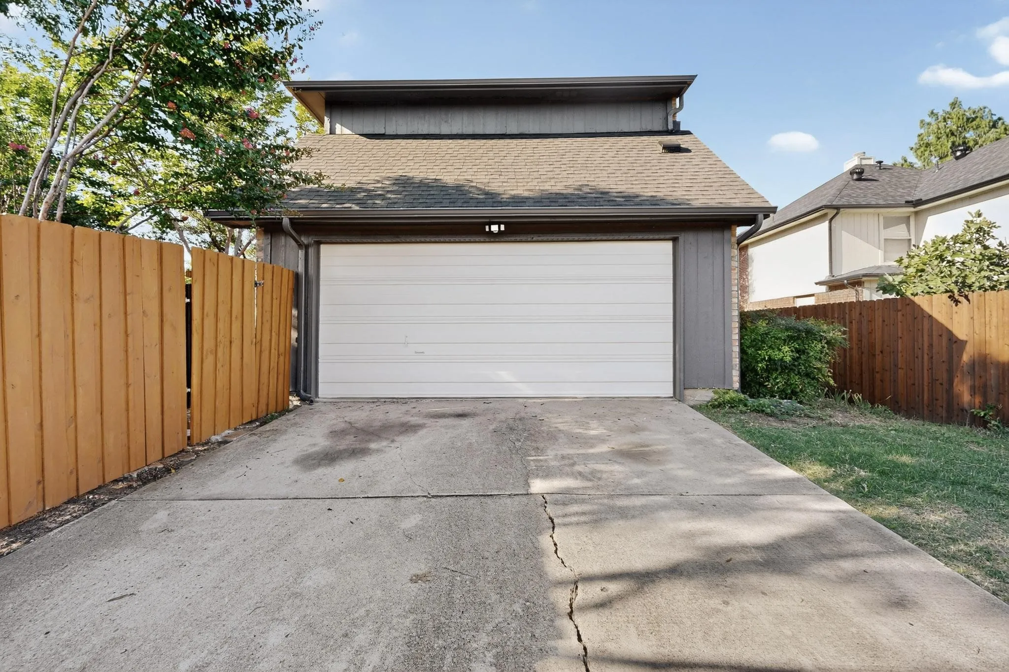 Attached single-car garage with a white sectional door and an overhead light fixture