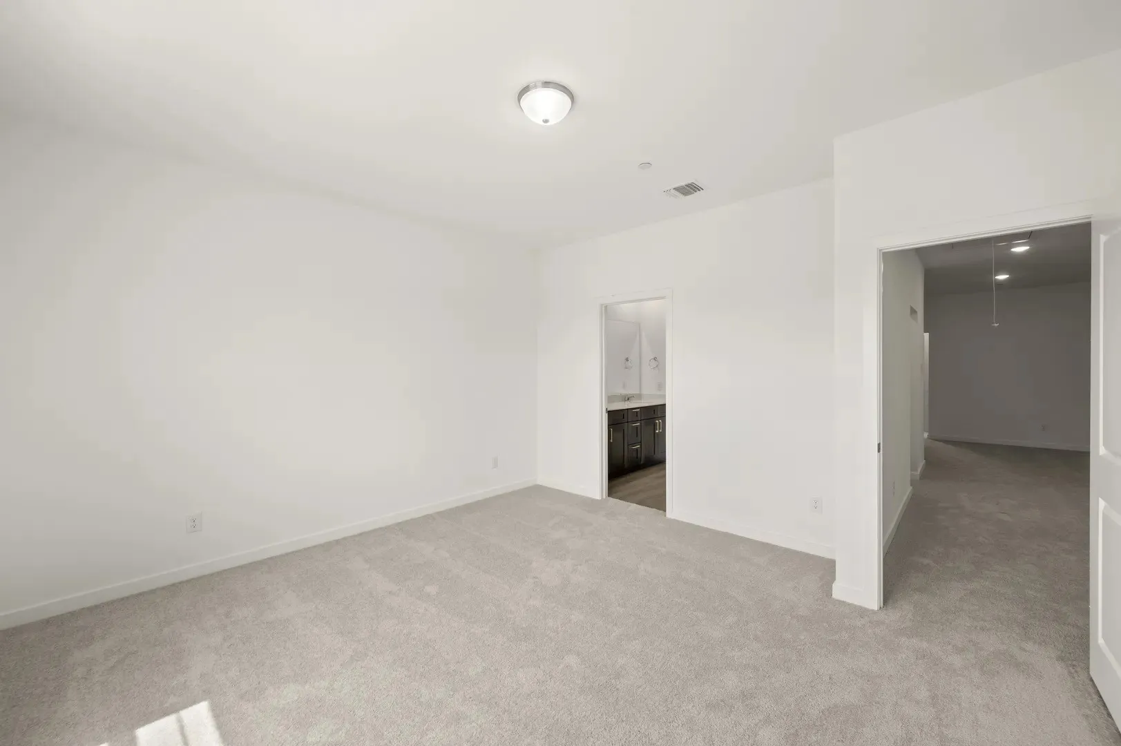 Spacious room featuring light-toned carpeting and a neutral wall color