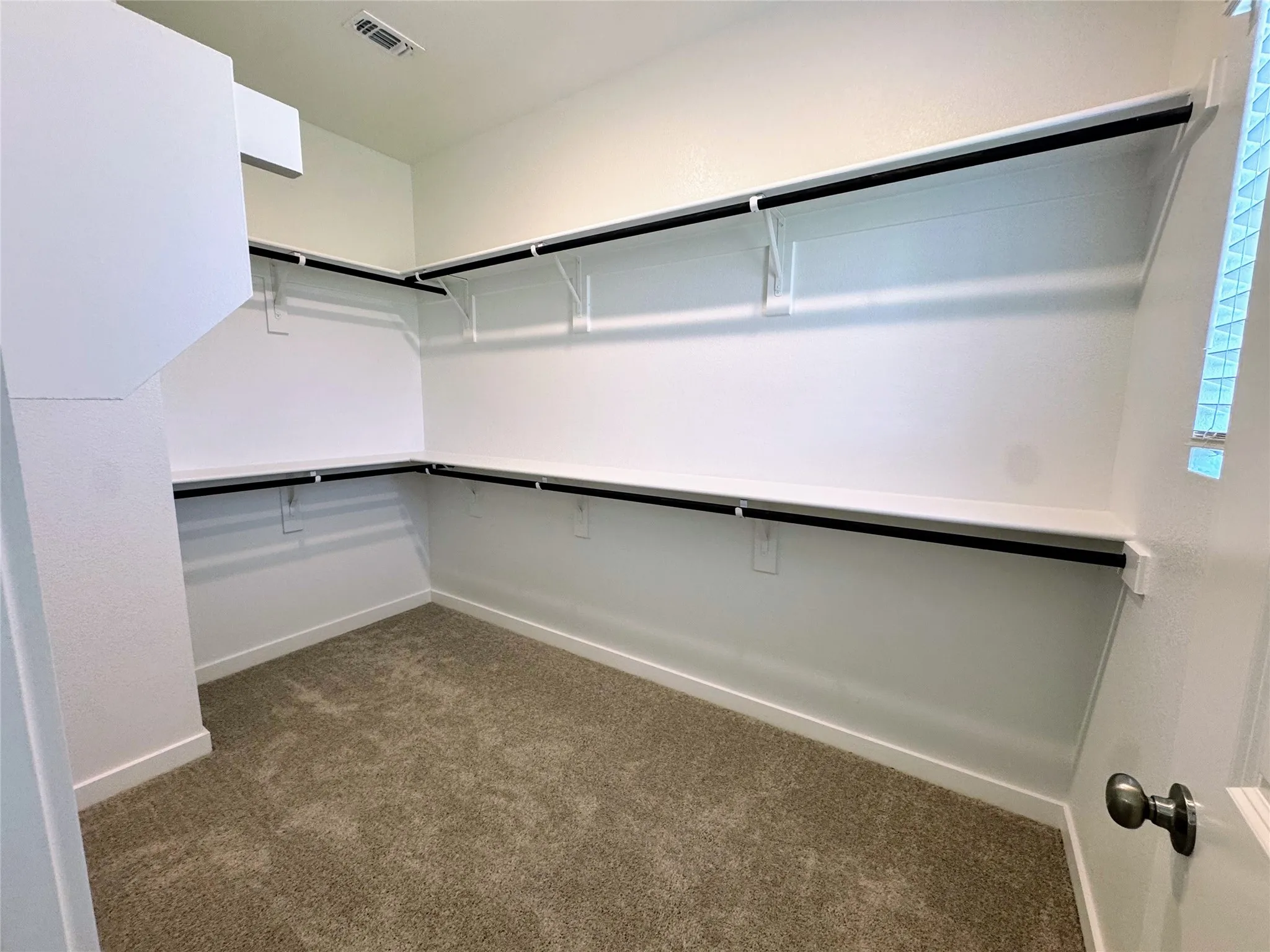 Expansive closet featuring built-in shelving and hanging rods