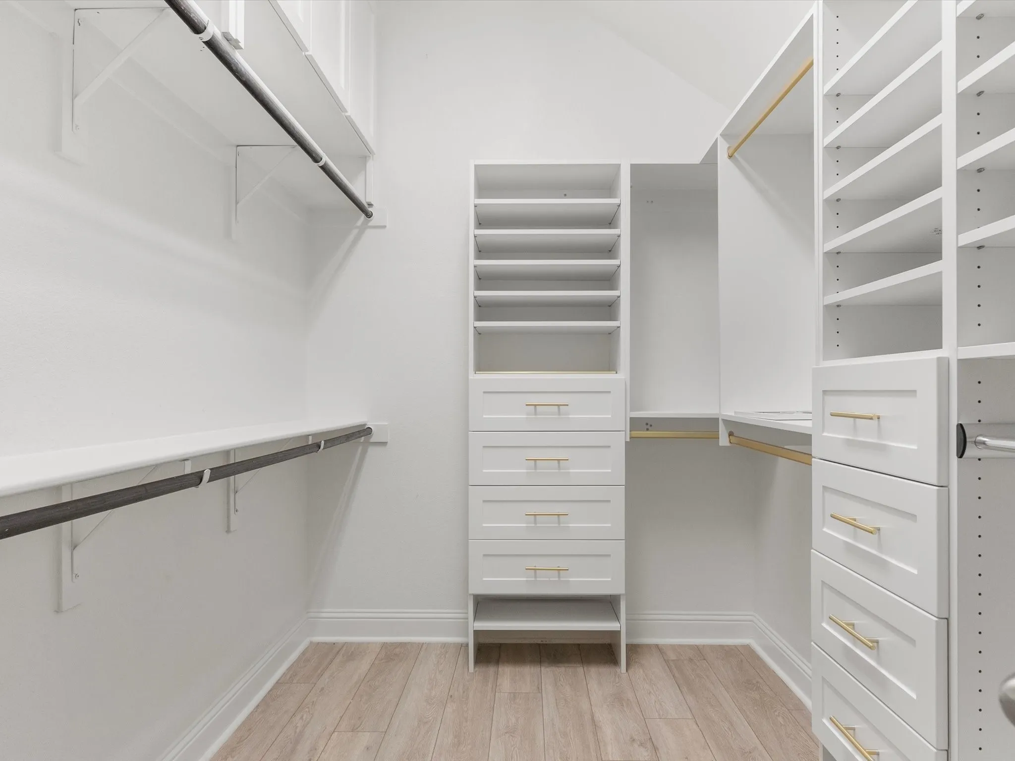 Custom closet system featuring multiple drawers, shelving, and hanging rods