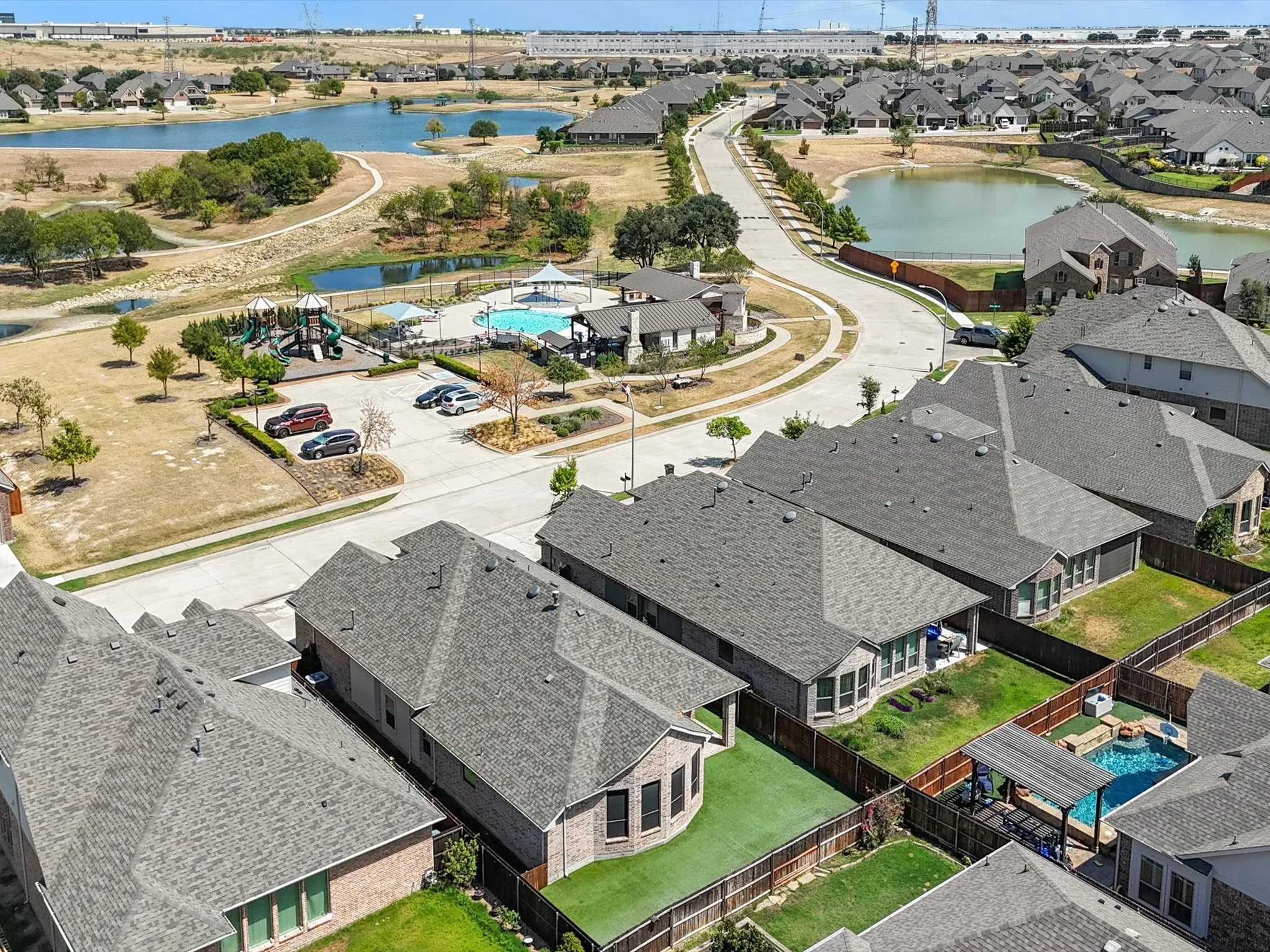 Aerial perspective highlighting a residential development with multiple private properties, a community pool, and a playground