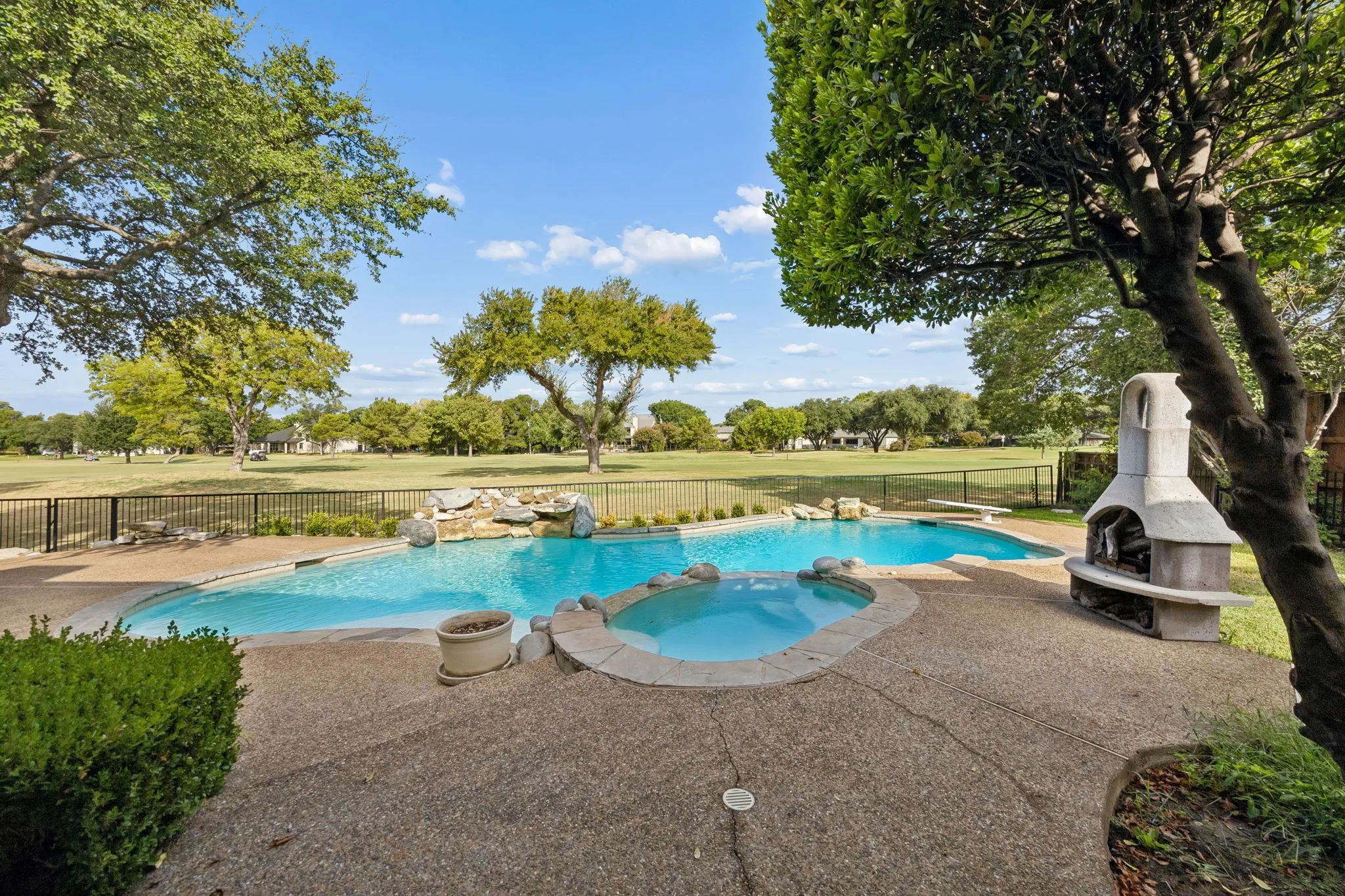 Expansive backyard featuring a freeform swimming pool, integrated spa, and a rock waterfall feature