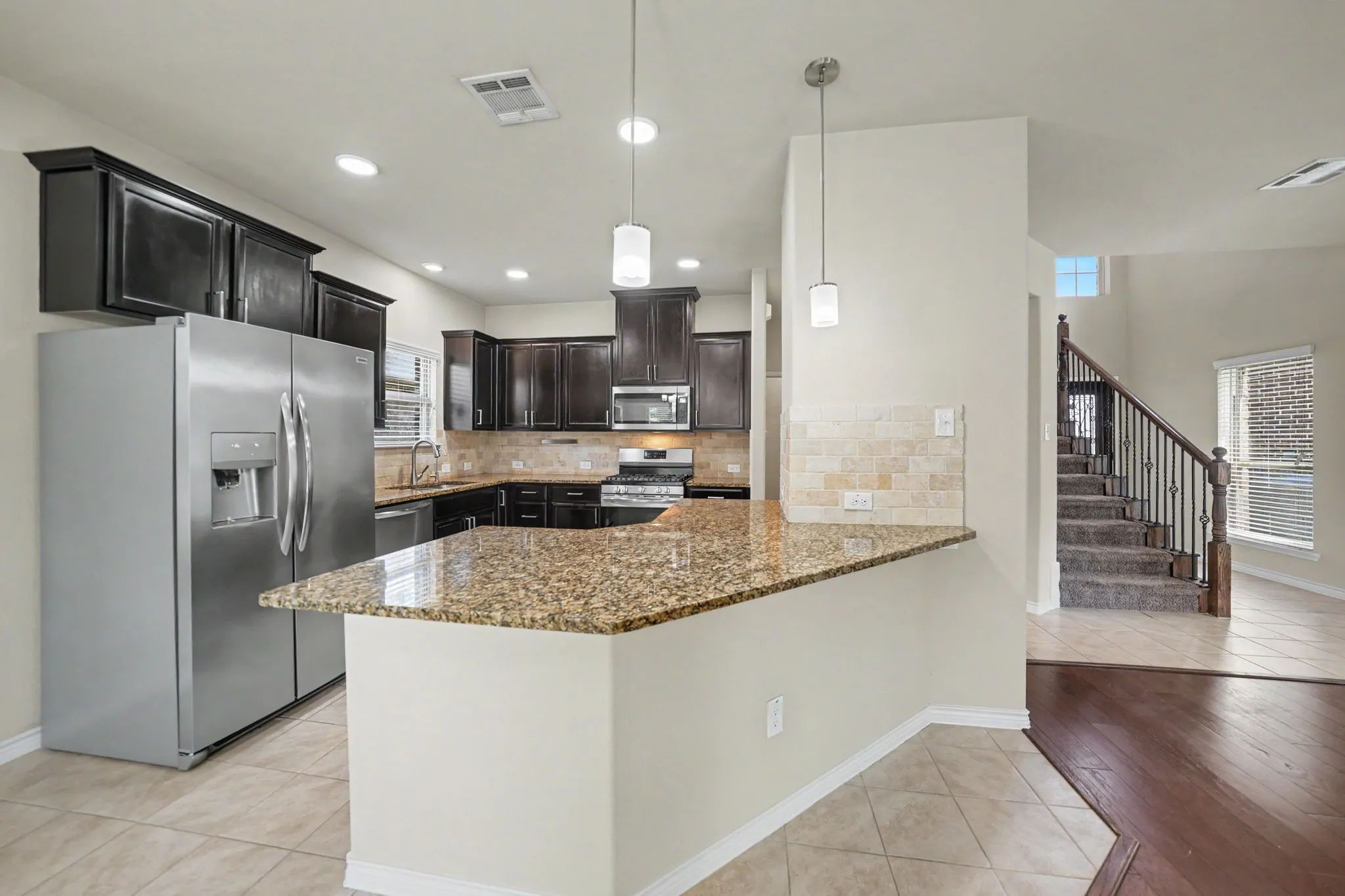 Kitchen featuring dark wood cabinetry, granite countertops, and stainless steel appliances