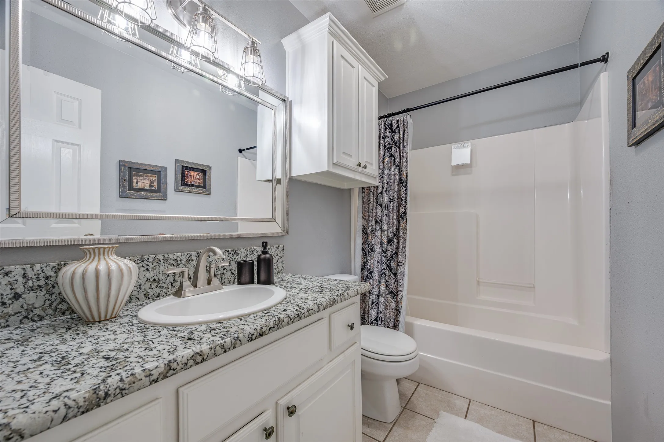 The second bathroom is for guests and shared between bedrooms two and three.  It features a nice sized vanity with a large mirror and additional storage!