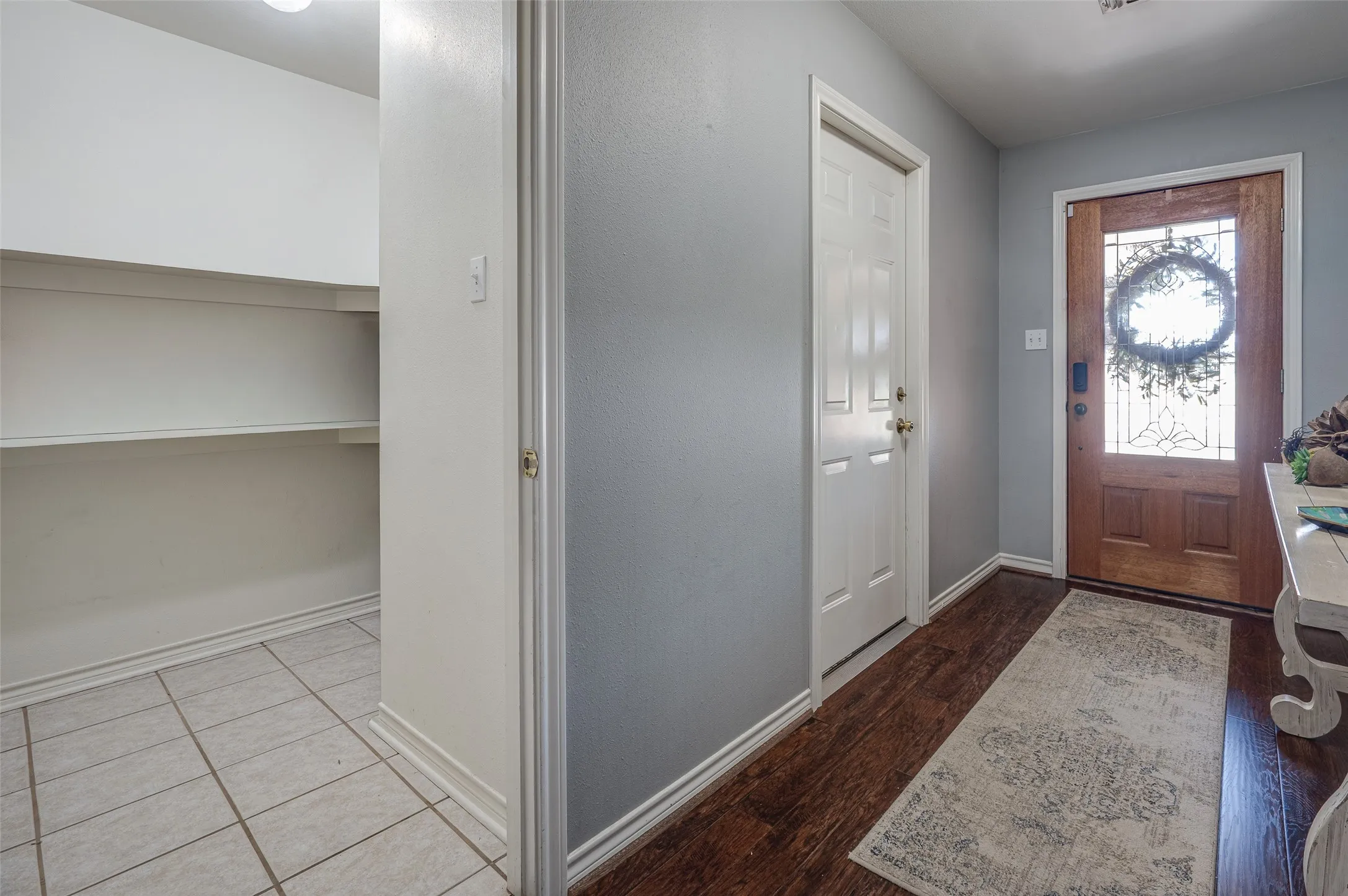View of the foyer and the front door with access to the second pantry or large storage area for bulk shopping, seasonal items or miscellaneous storage.