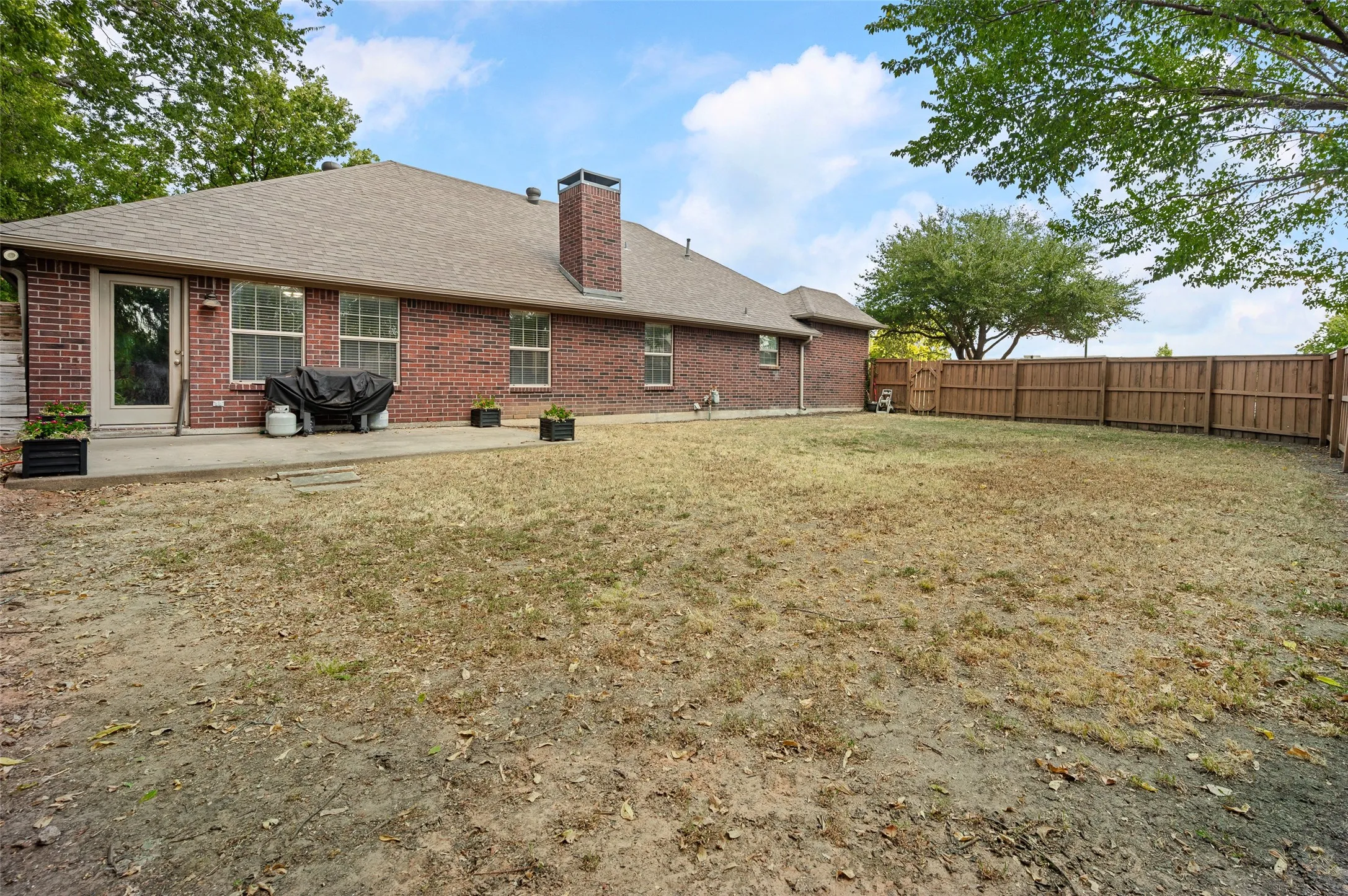 The back of the home has a patio for grilling and entertaining and an abundance of yard space.