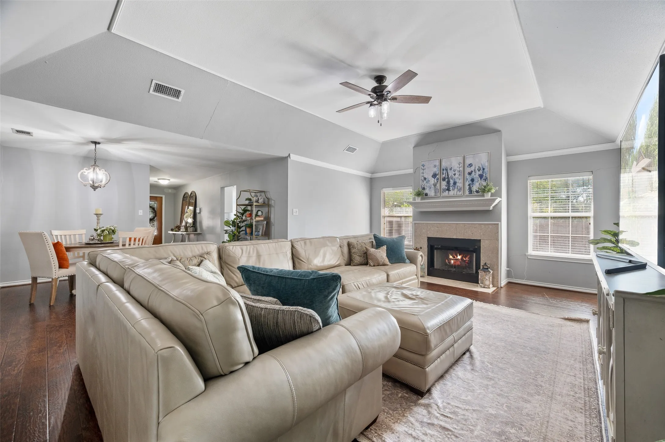 Living room and dining room feature architecturally elaborate touches with crown molding, tray ceiling, and beautiful fireplace.