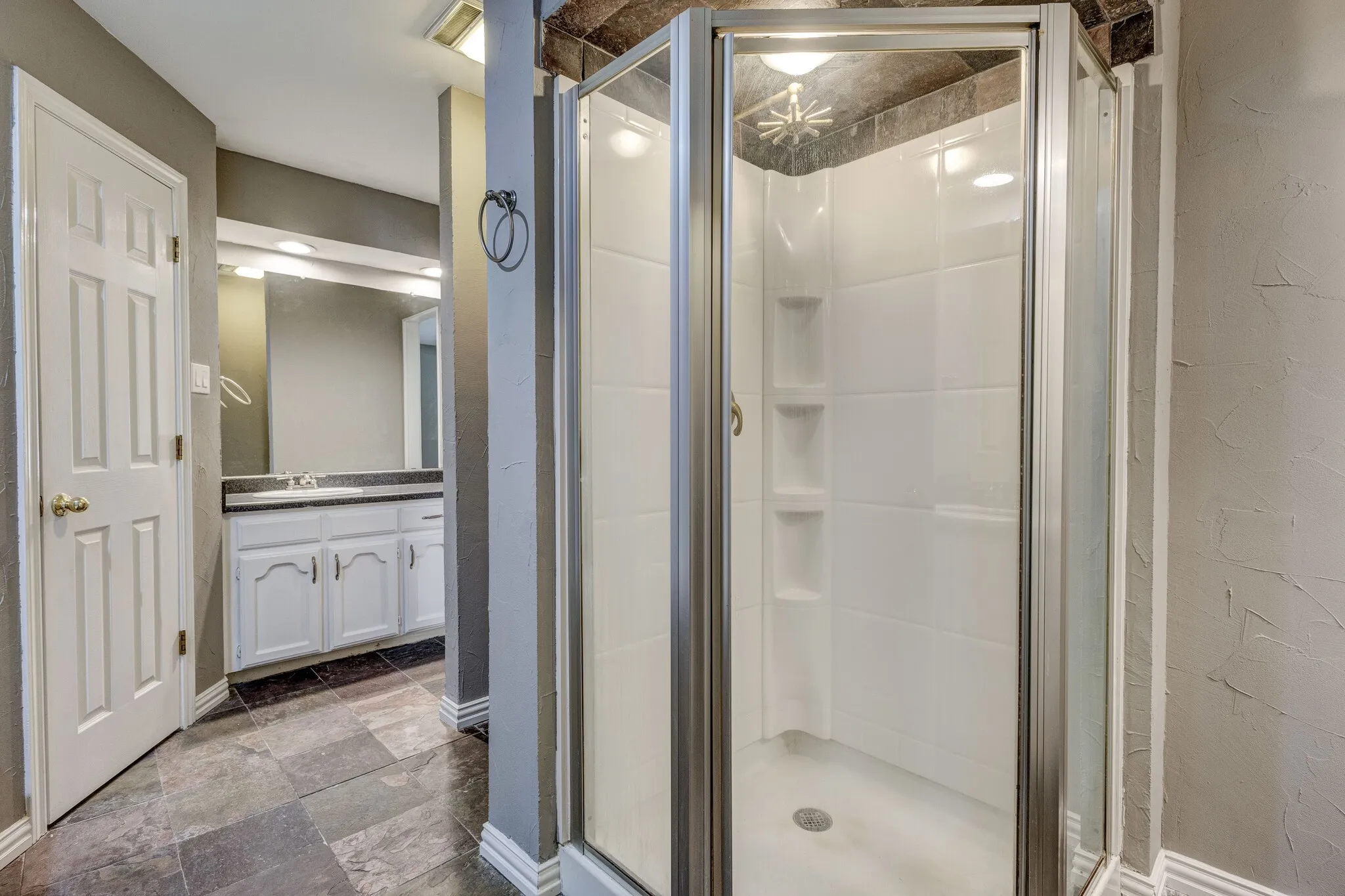 Enclosed glass shower stall with white paneling