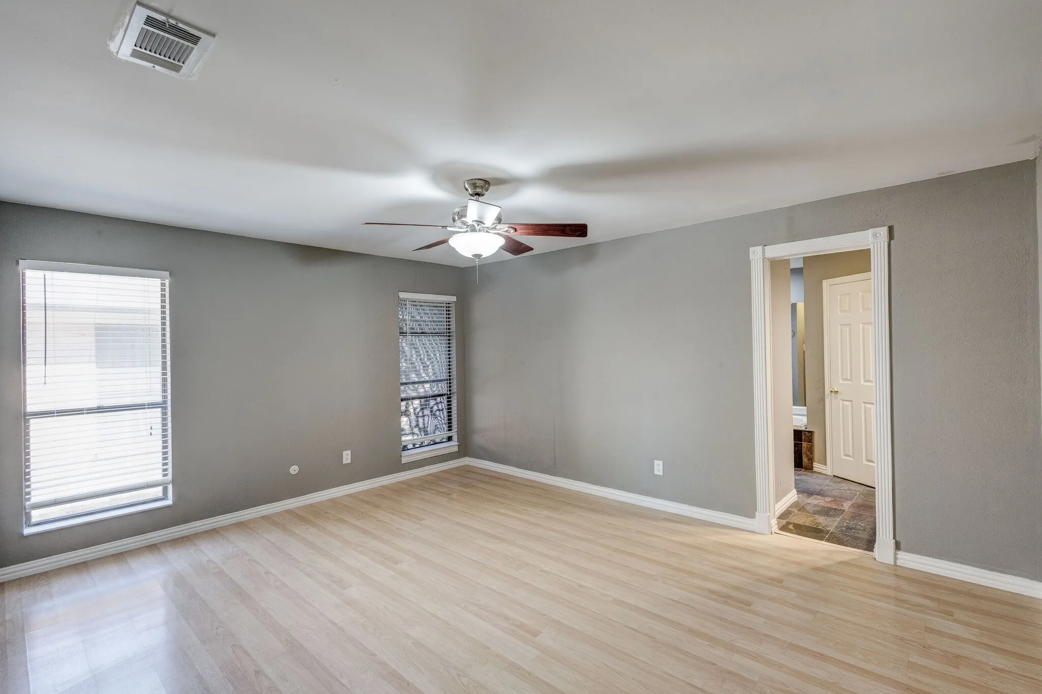 Wood-finish flooring with neutral wall paint and white trim