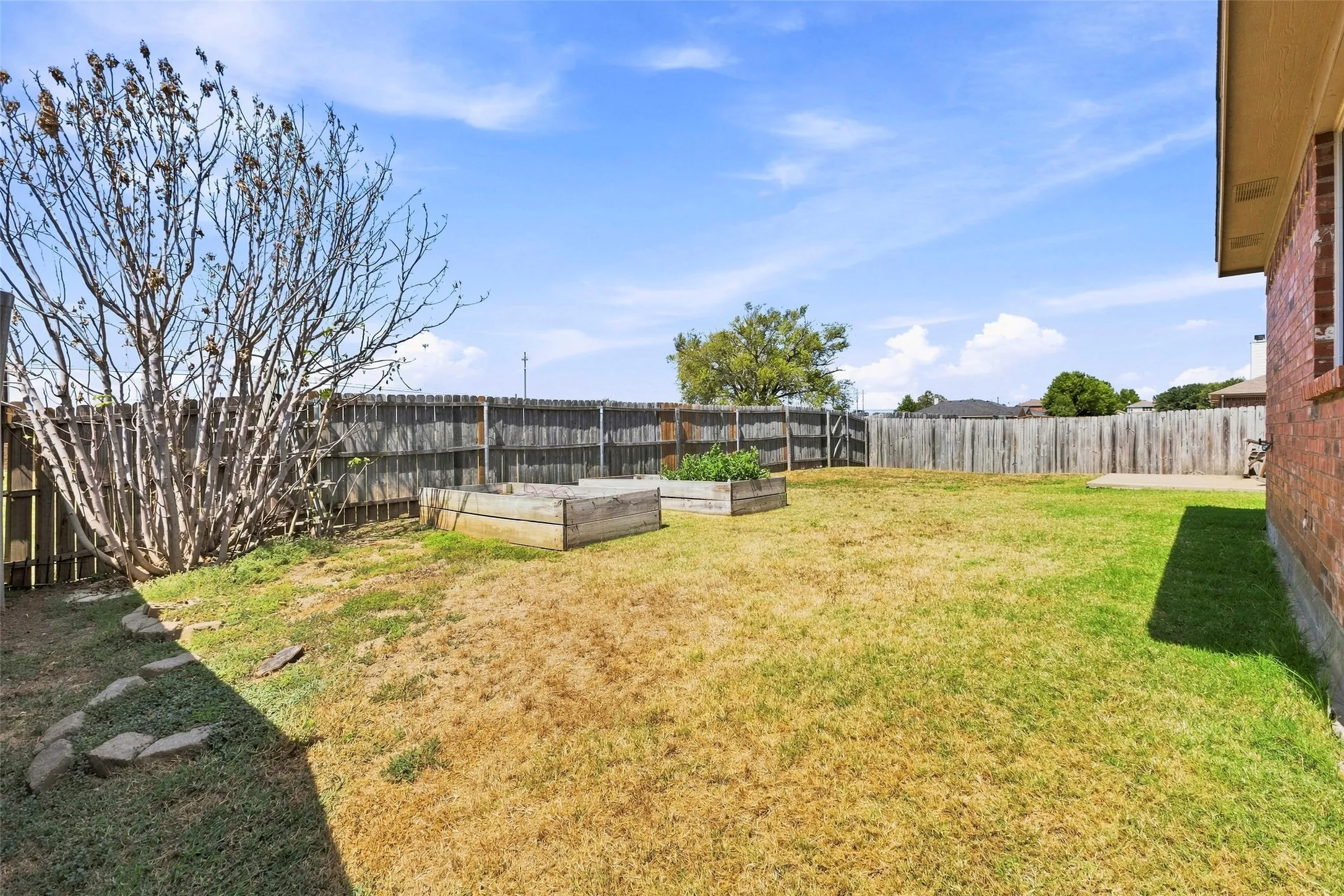 Huge backyard with patio and garden boxes with open space behind