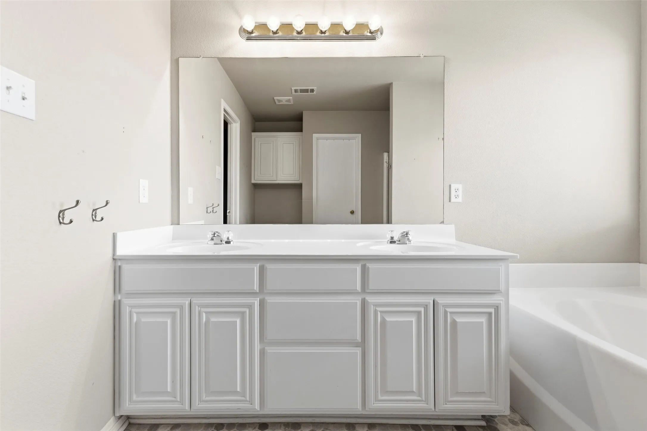 The primary bathroom has double sinks and separate tub and shower