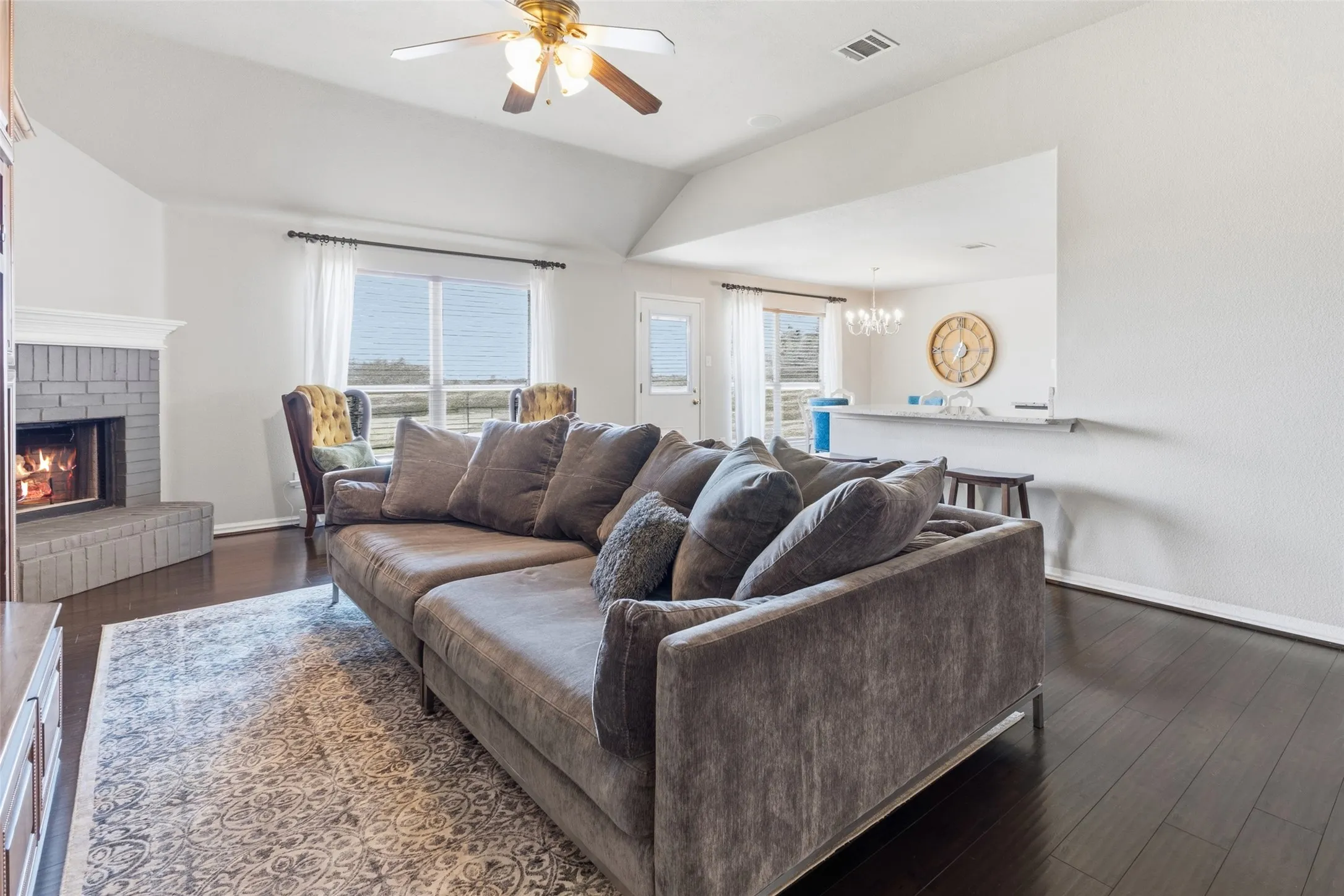 Large living room with tall ceilings and fireplace and is open to the kitchen