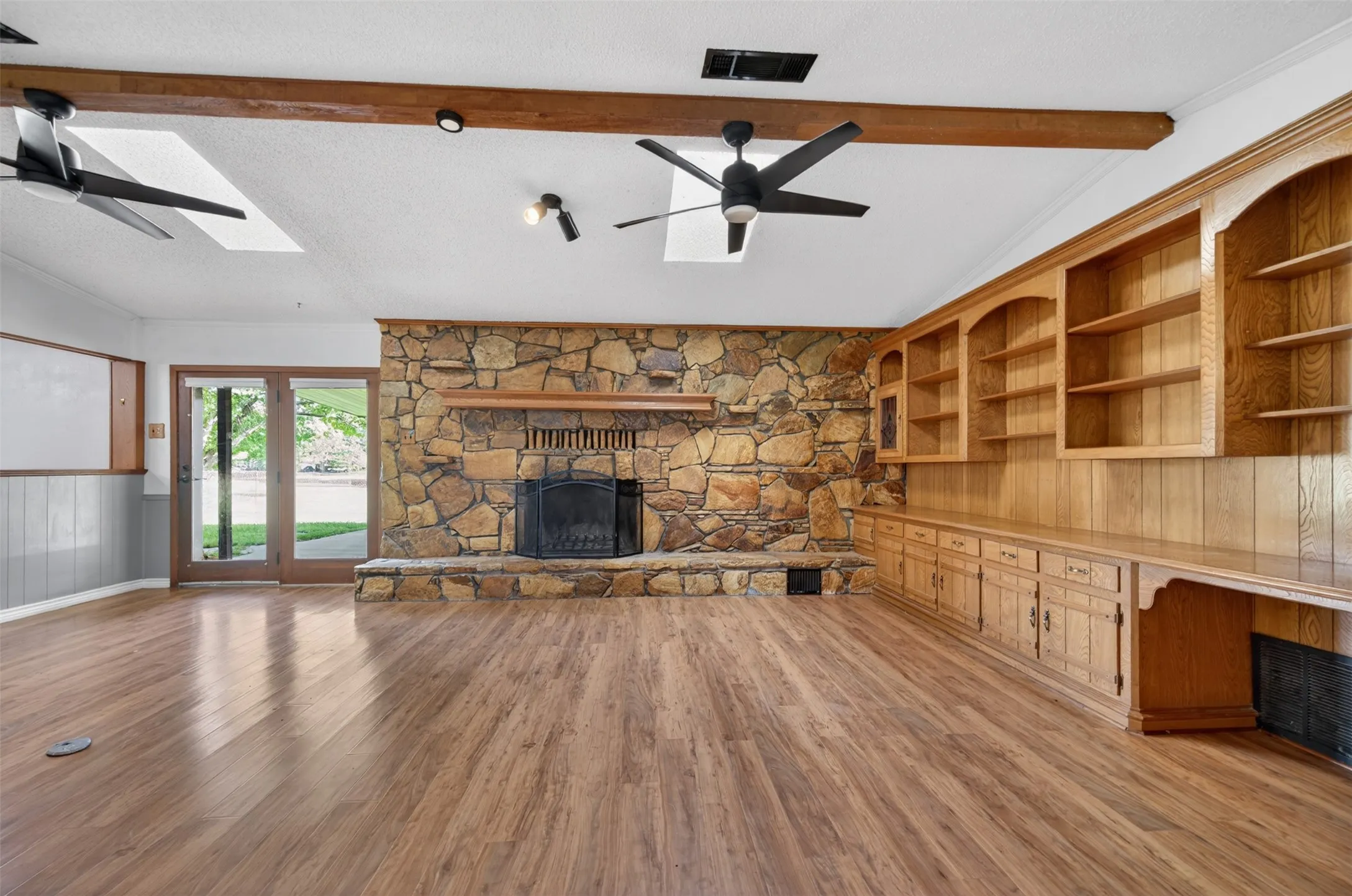 Living room with massive stone wood-burning fireplace and lots of built-ins