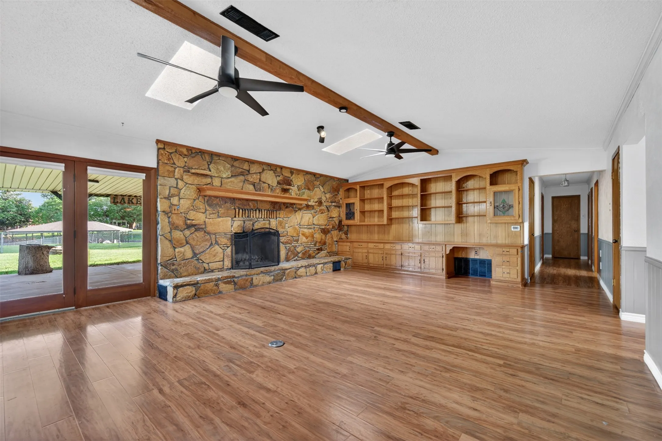 Living room with massive stone wood-burning fireplace and lots of built-ins