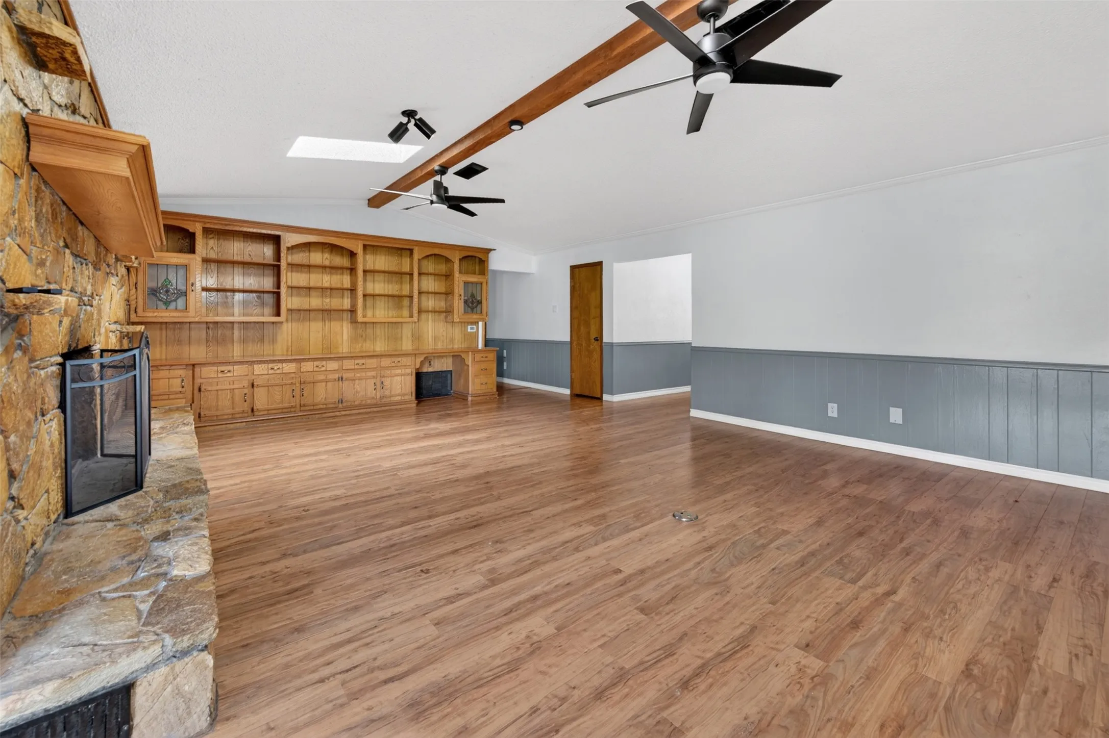 Living room with massive stone wood-burning fireplace and lots of built-ins
