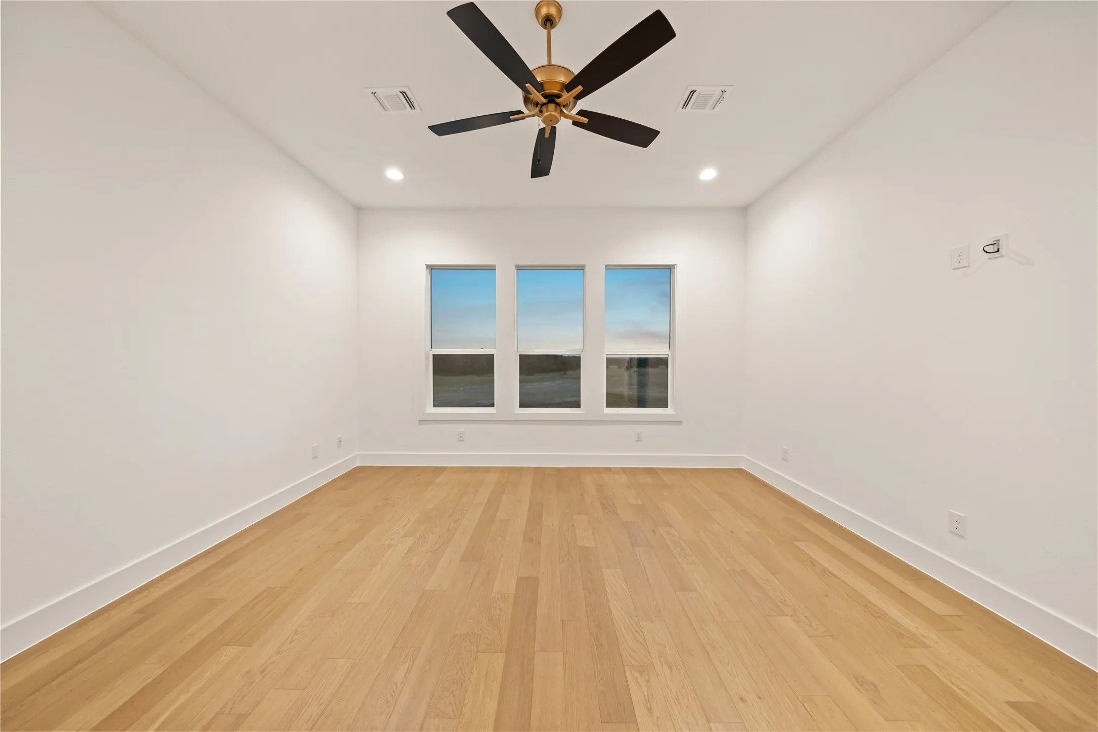 Hardwood-finish flooring, recessed lighting, and a ceiling fan with integrated lighting