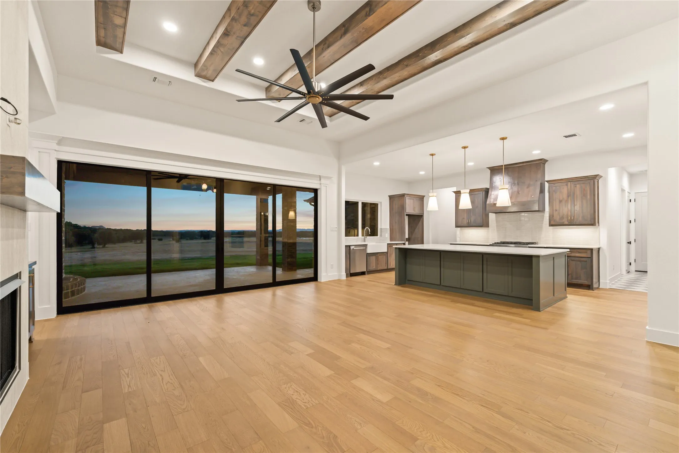 Wood-finish flooring throughout, with a large kitchen island featuring pendant lighting