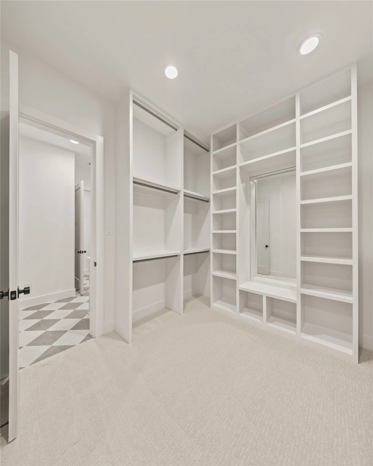 Built-in custom shelving, recessed lighting, checkerboard tile flooring, plush carpet flooring, and matte black door hardware