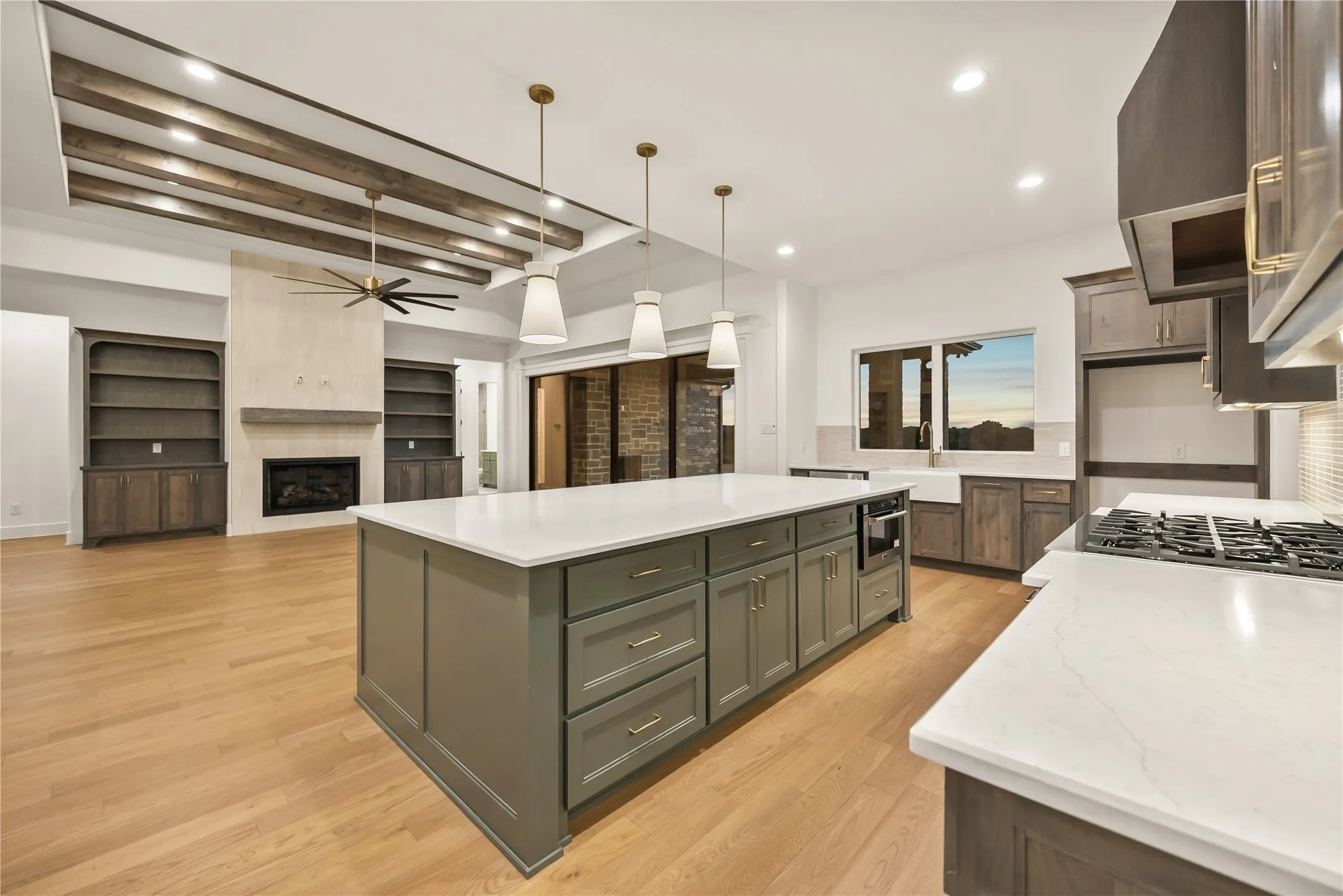 Gourmet kitchen with white countertops and a large central island, featuring a built-in microwave