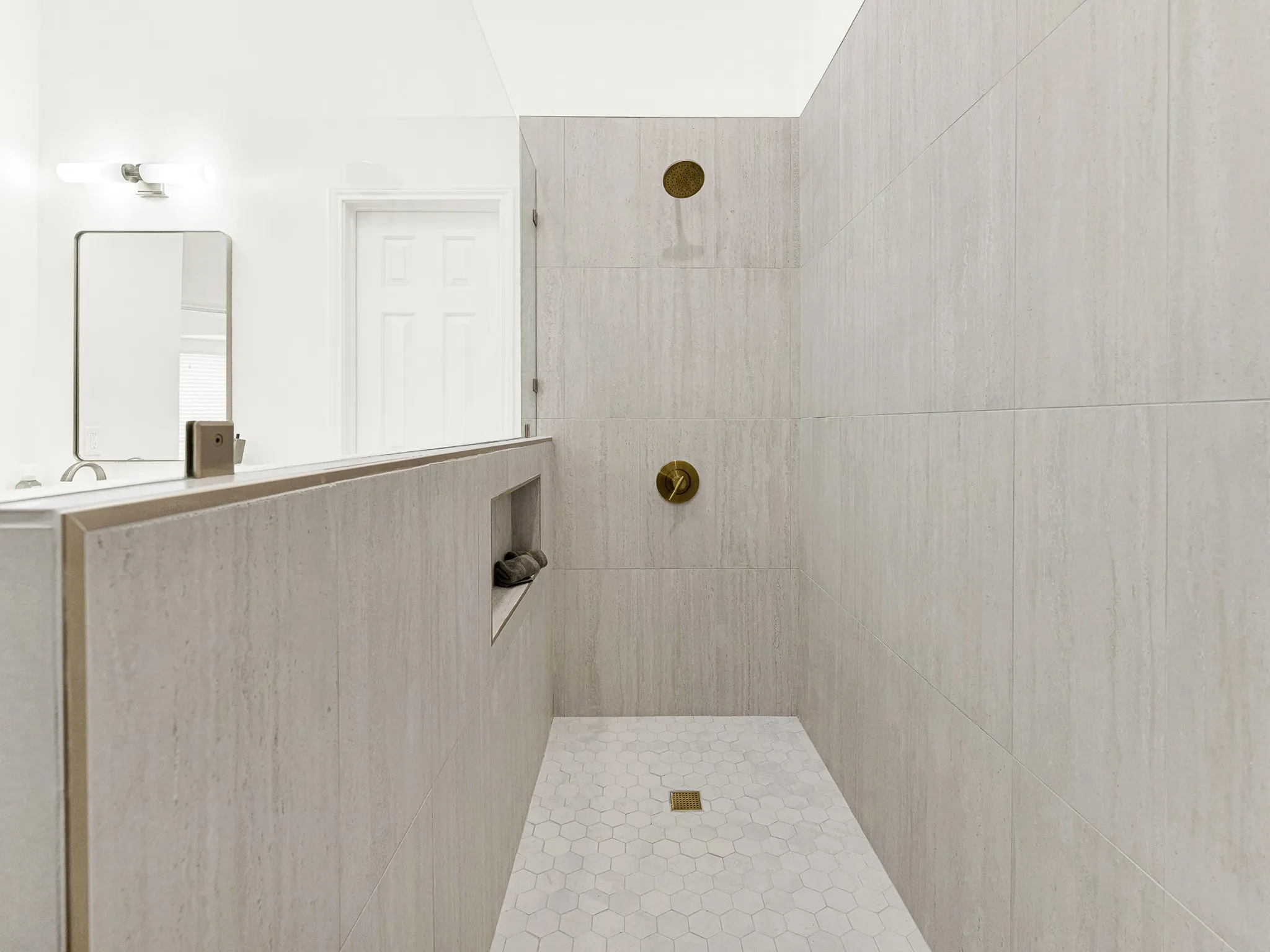 Over sized walk in shower with ample space to hold products while showering.