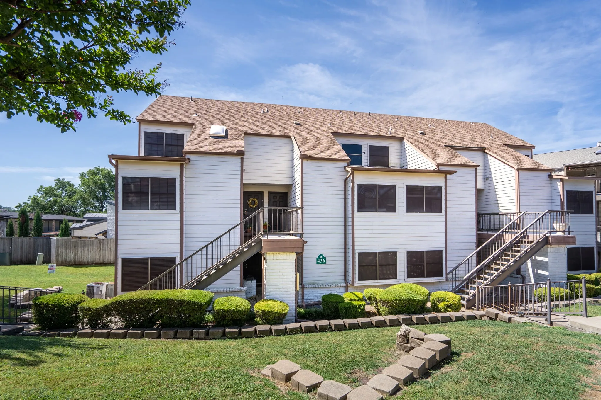 Multi-story dwelling featuring white siding and brown trim
