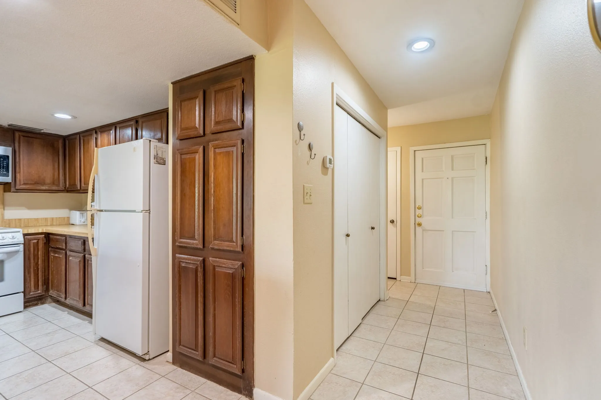 Kitchen featuring wood cabinetry, solid surface countertops, and tile flooring